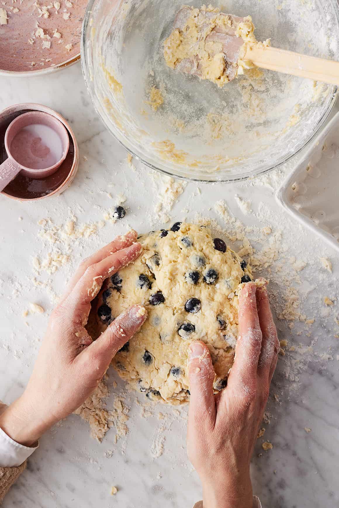 Forming blueberry scone dough into disk