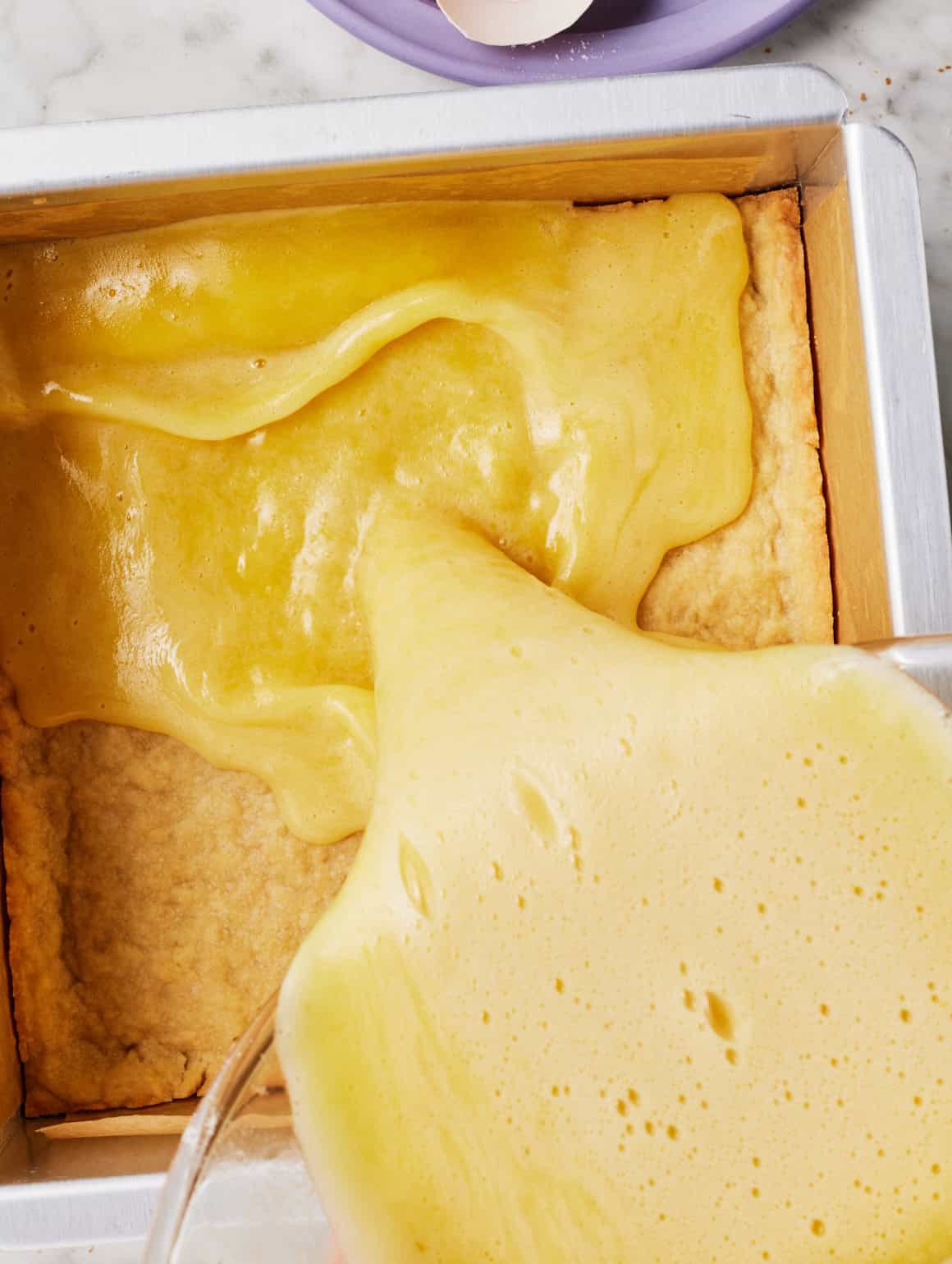 Pouring lemon mixture over hot crust