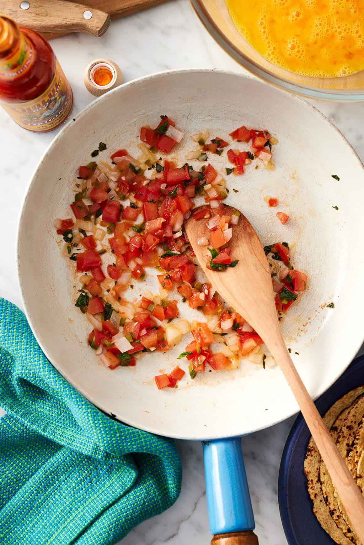 Pico de gallo in medium skillet with wooden spoon