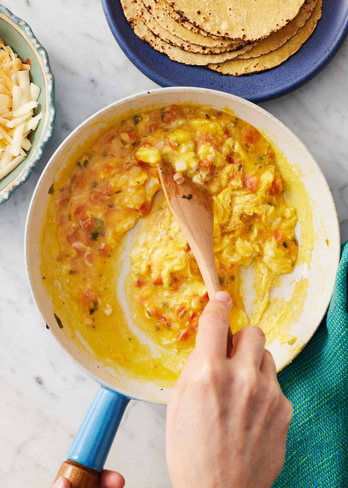 Scrambling eggs with pico de gallo in medium skillet