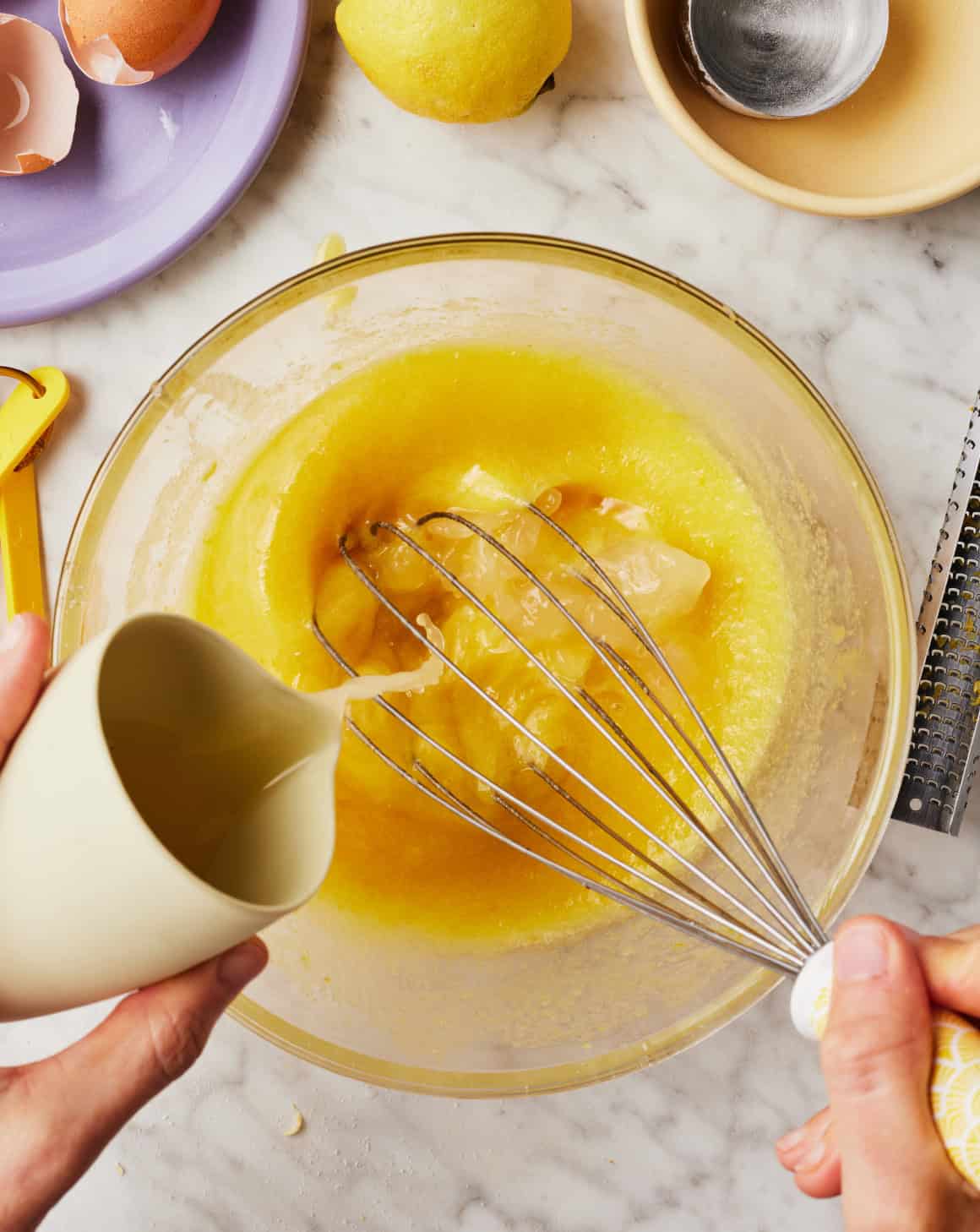 Whisking lemon filling ingredients in glass bowl