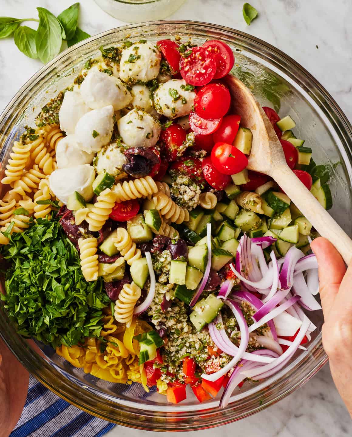 Tossing salad ingredients with Italian dressing in mixing bowl