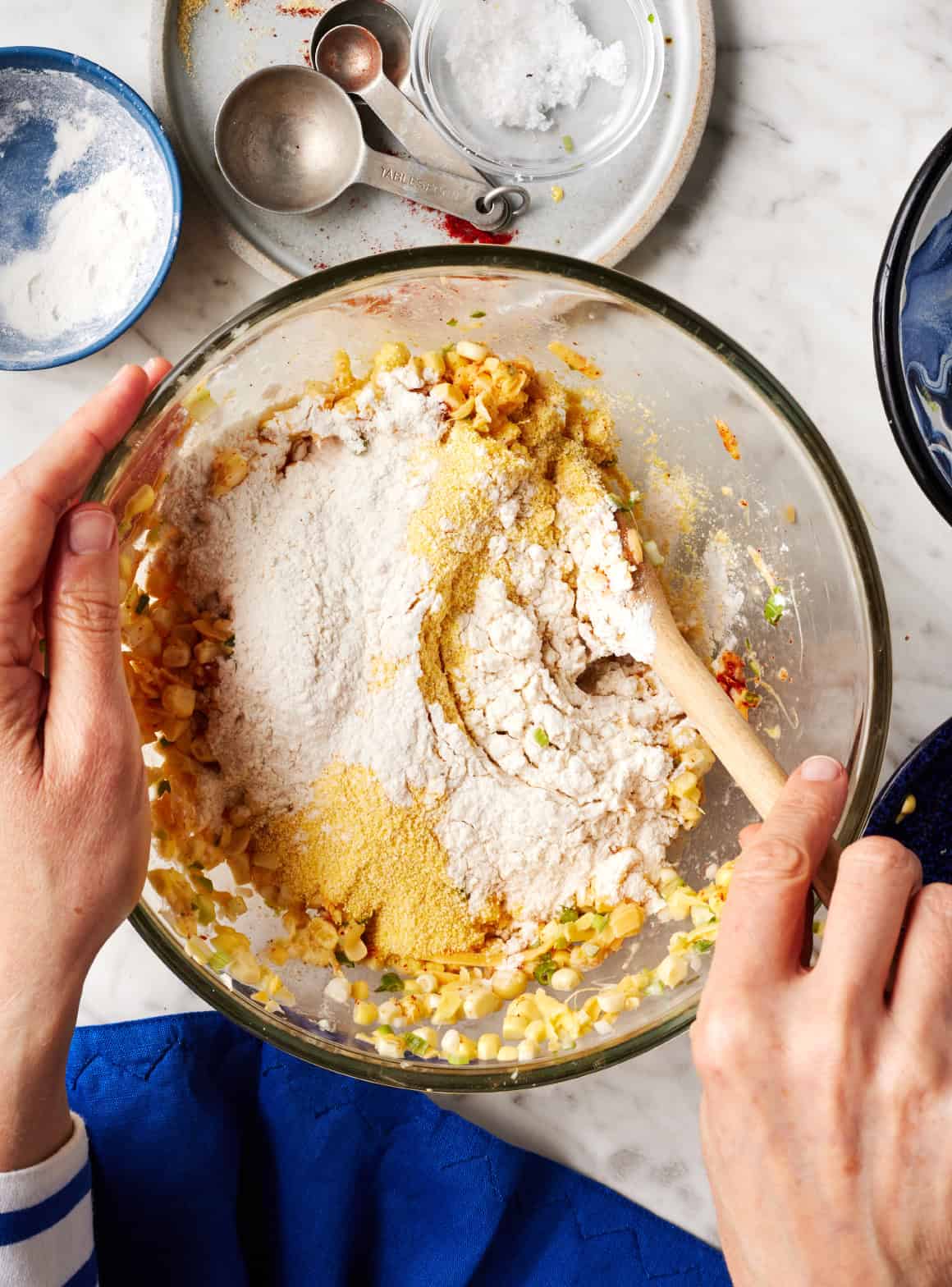 Adding flour and cornmeal to other ingredients in mixing bowl