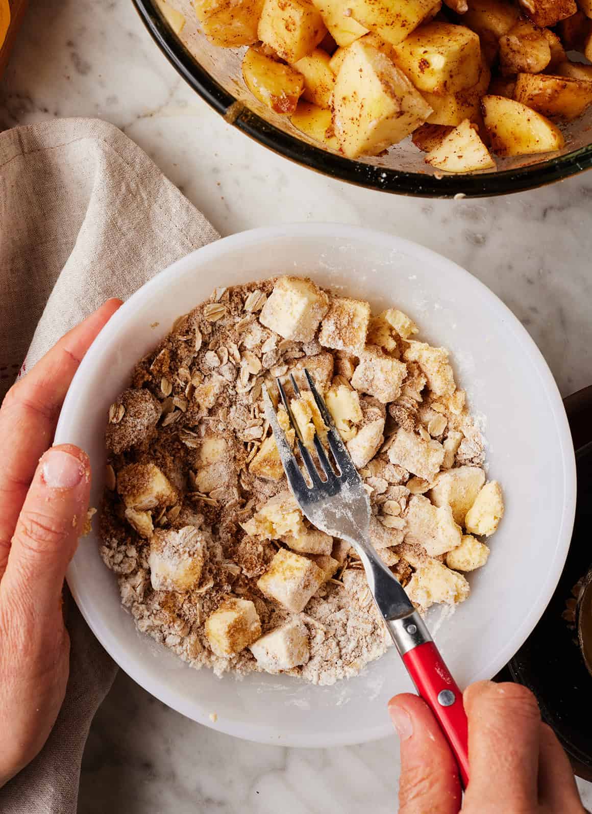 Using a fork, mix the butter into the flour and oat mixture.