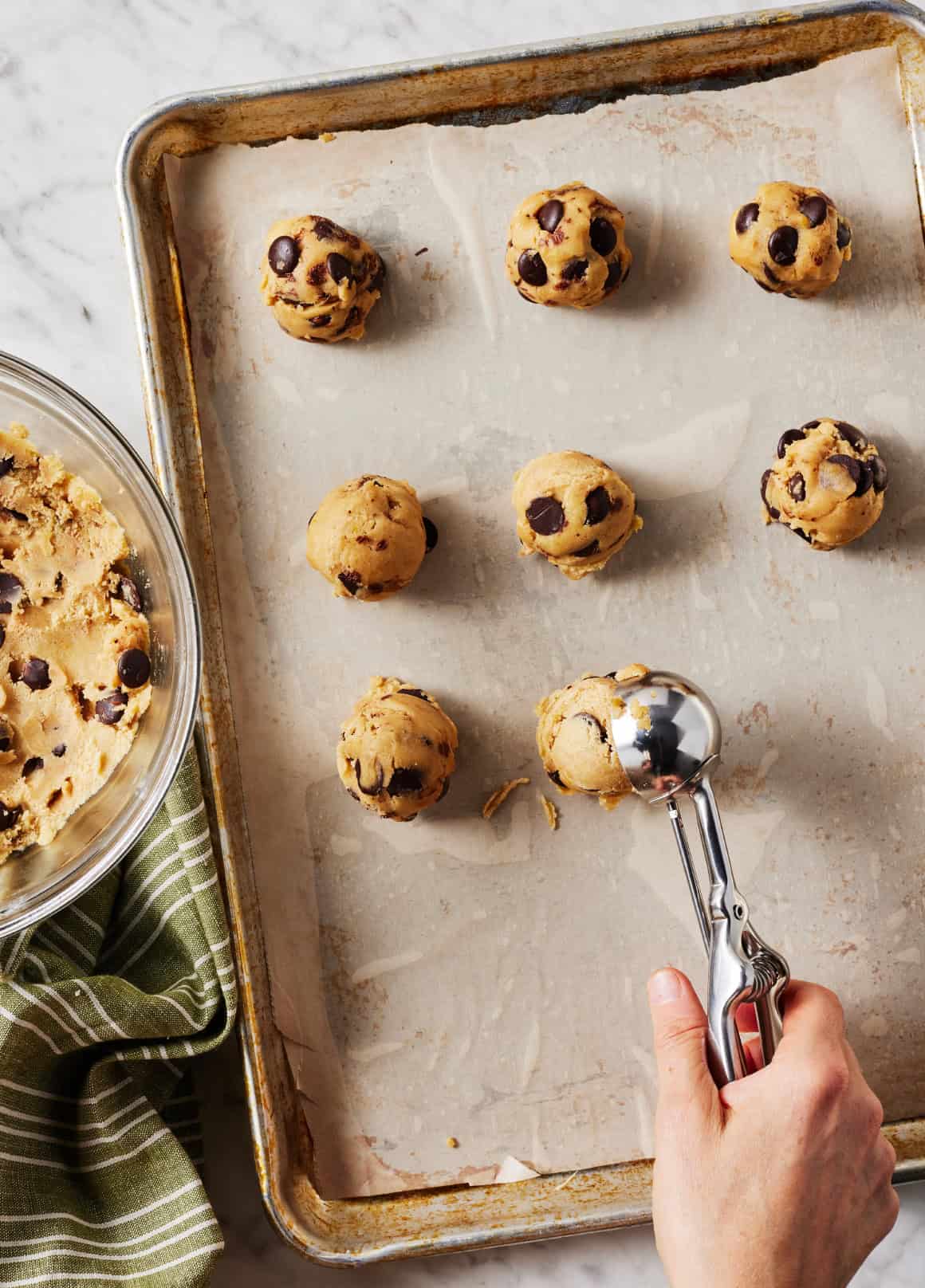 Scooping chocolate chip cookies onto baking sheet