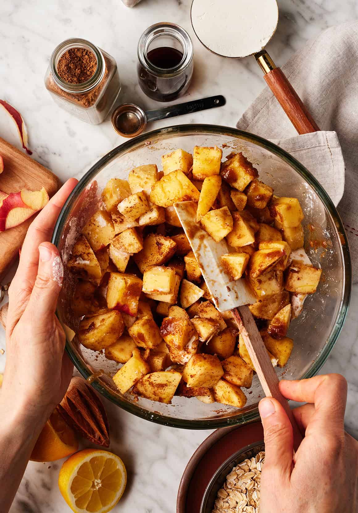 Apple pieces coated with a brown sugar and cinnamon mixture in a large bowl