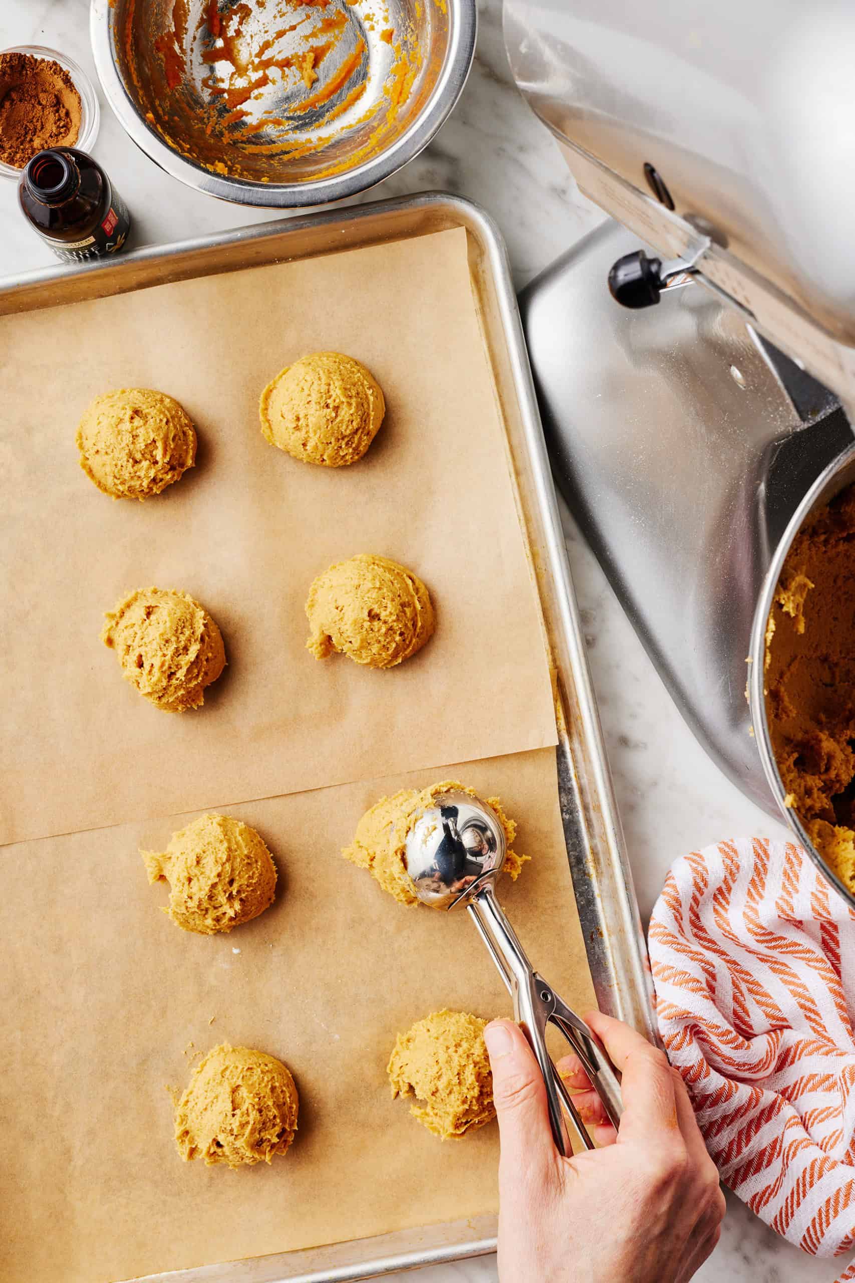 Scooping pumpkin cookie dough onto baking sheet