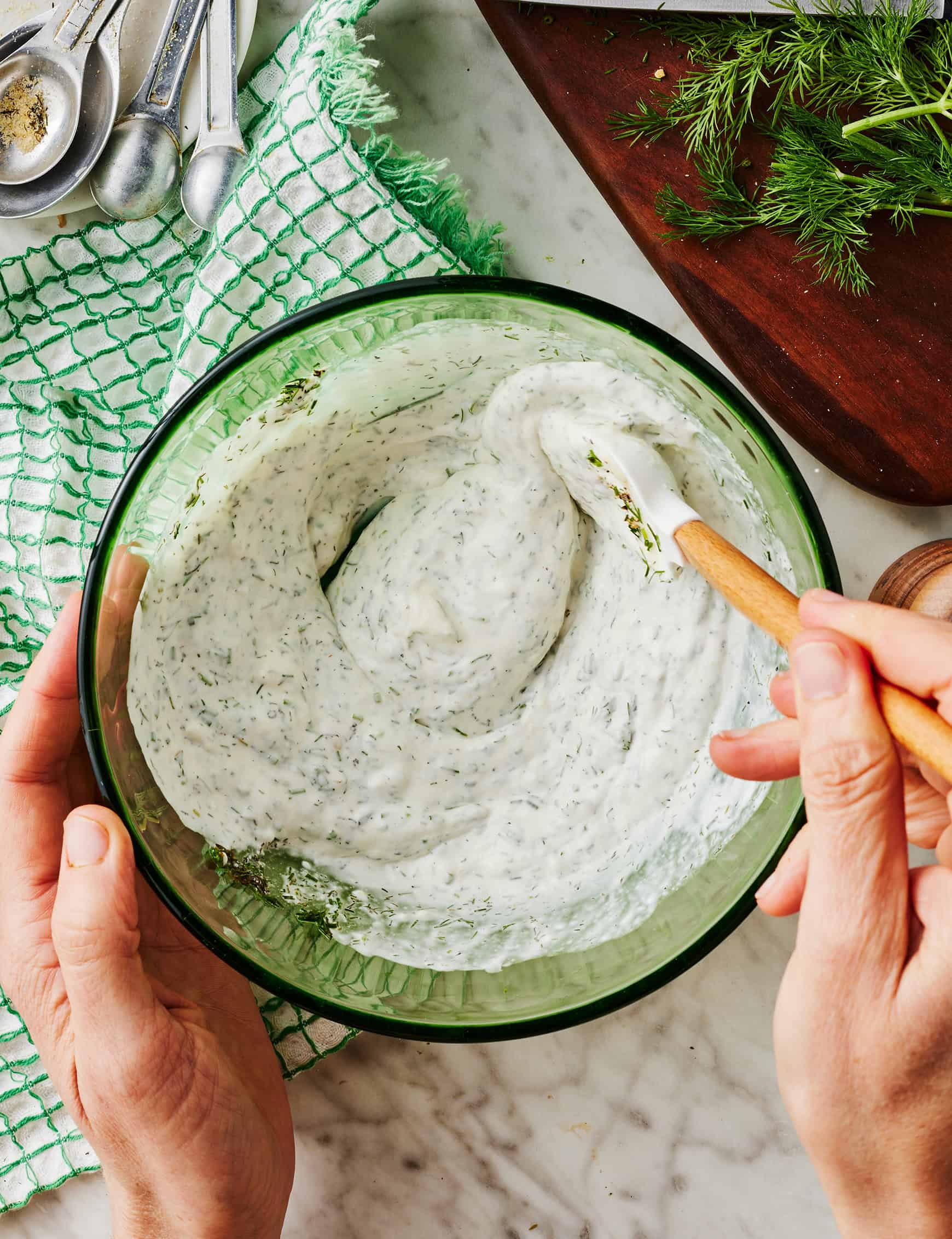 Mixing homemade ranch dressing in glass bowl