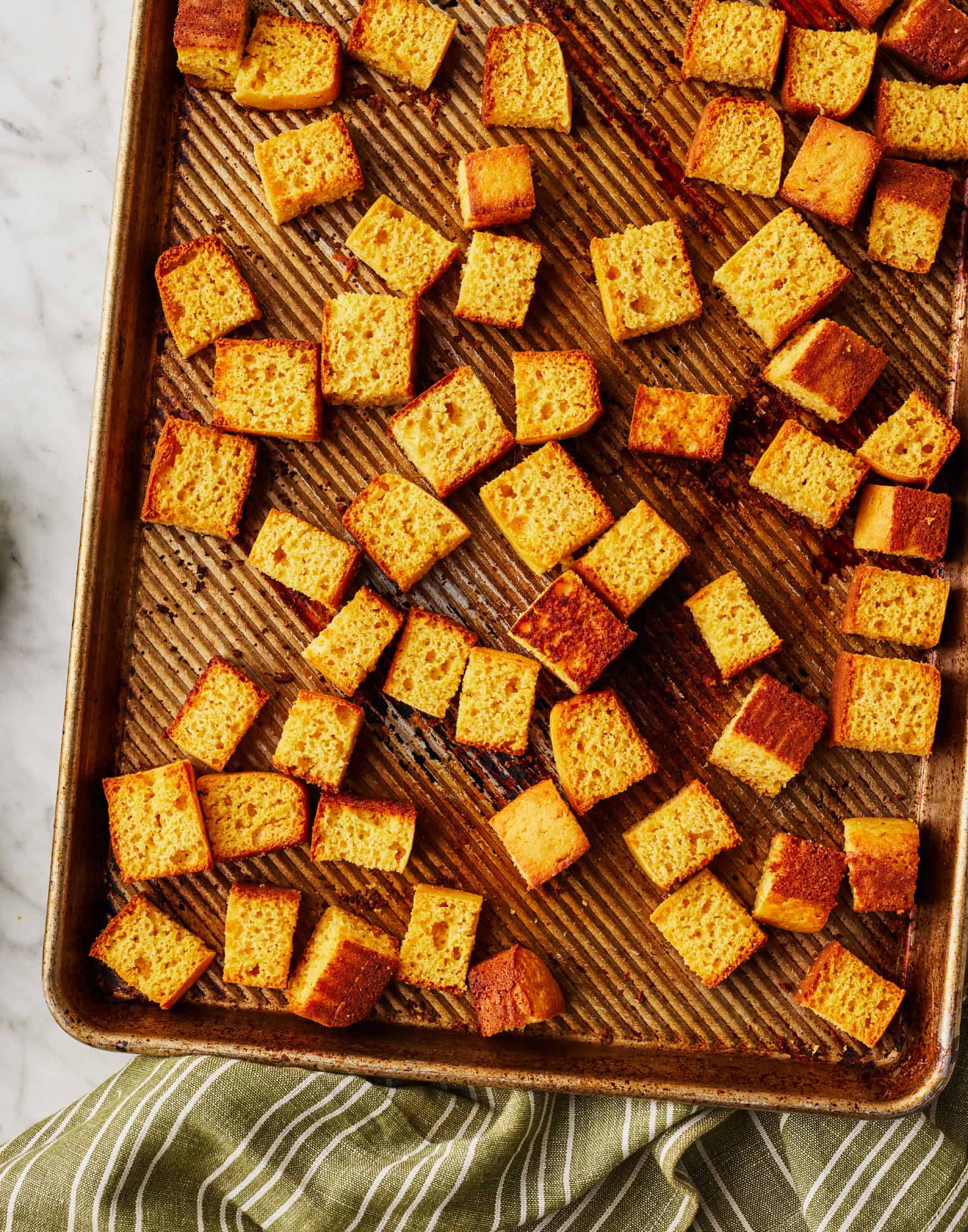 Cubed cornbread on a baking sheet