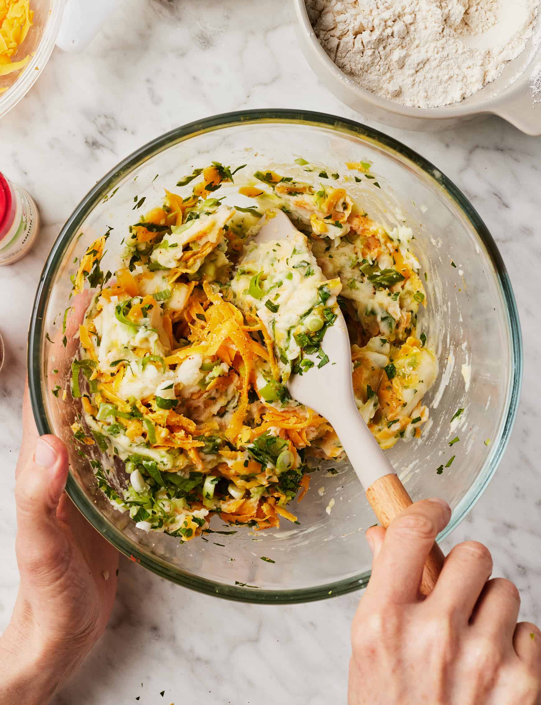 Stirring leftover potato mixture in glass mixing bowl