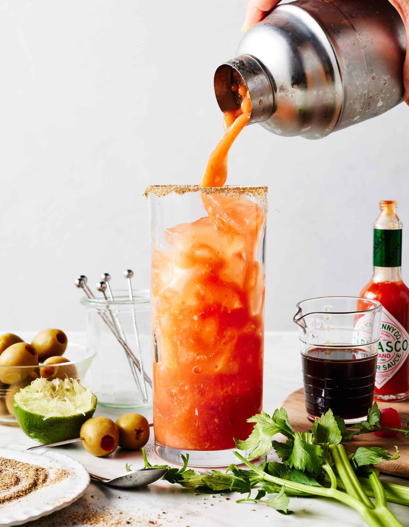 Pouring cocktail into glass with ice