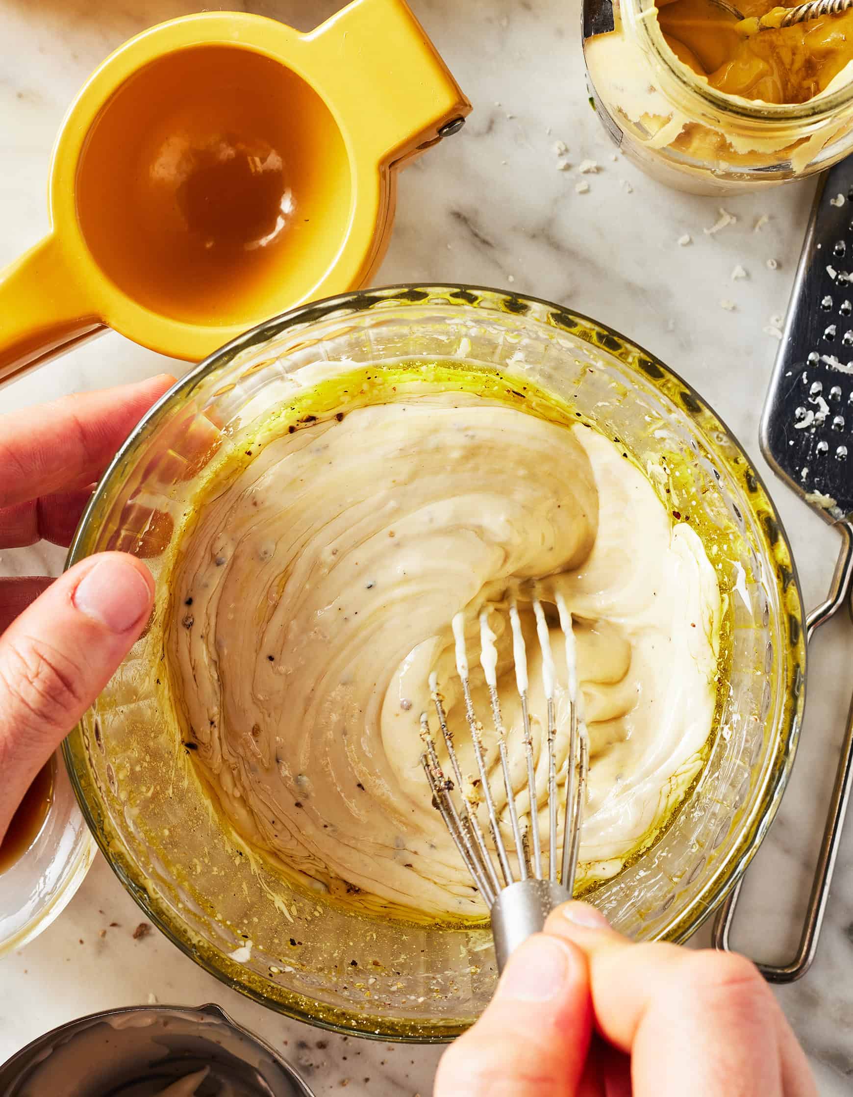 Whisking Caesar dressing in glass bowl