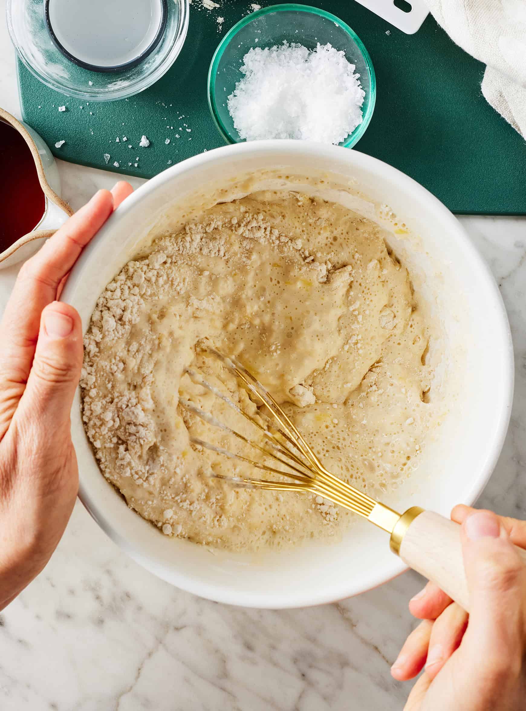 Mixing batter for pancakes in white bowl
