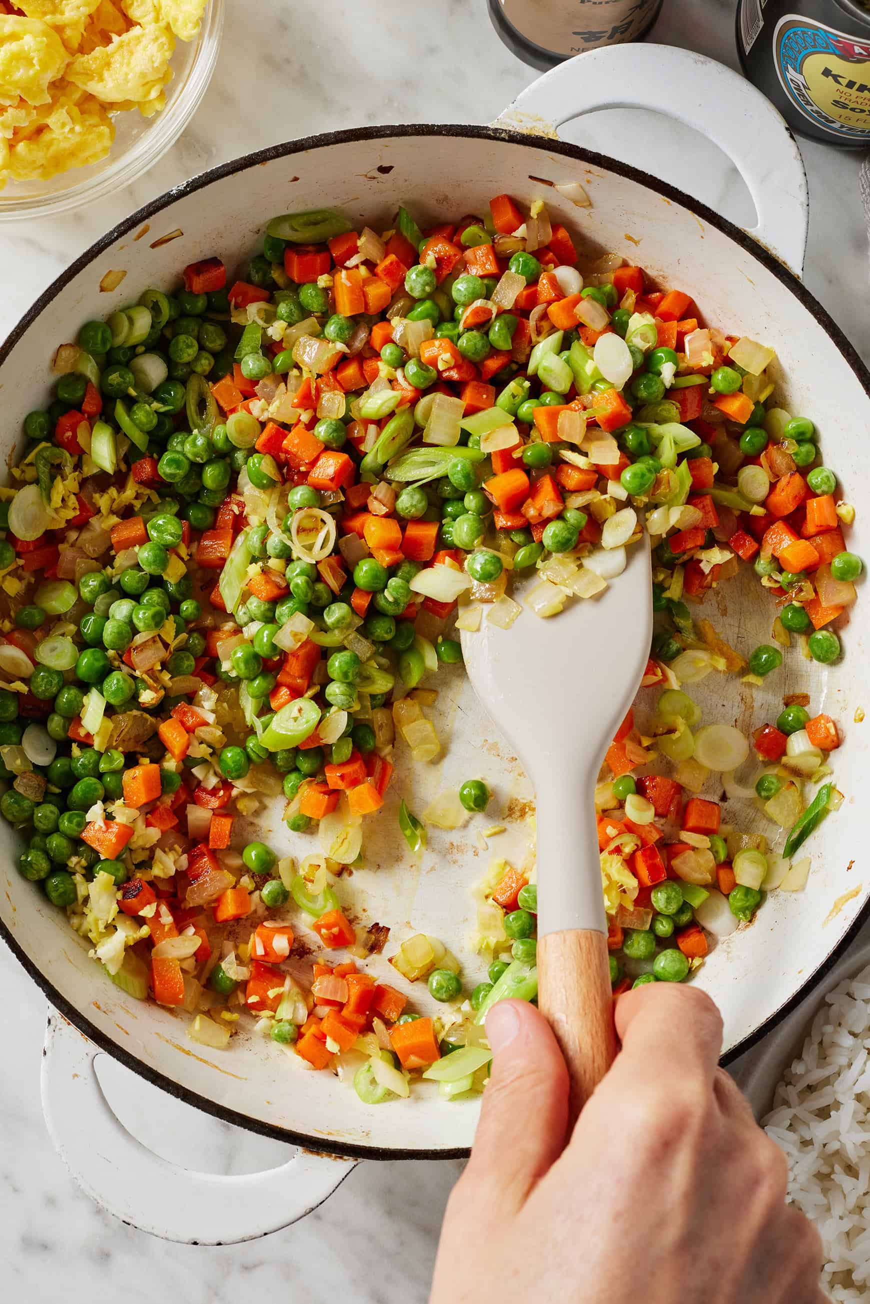 Stir frying onions, carrots, and peas