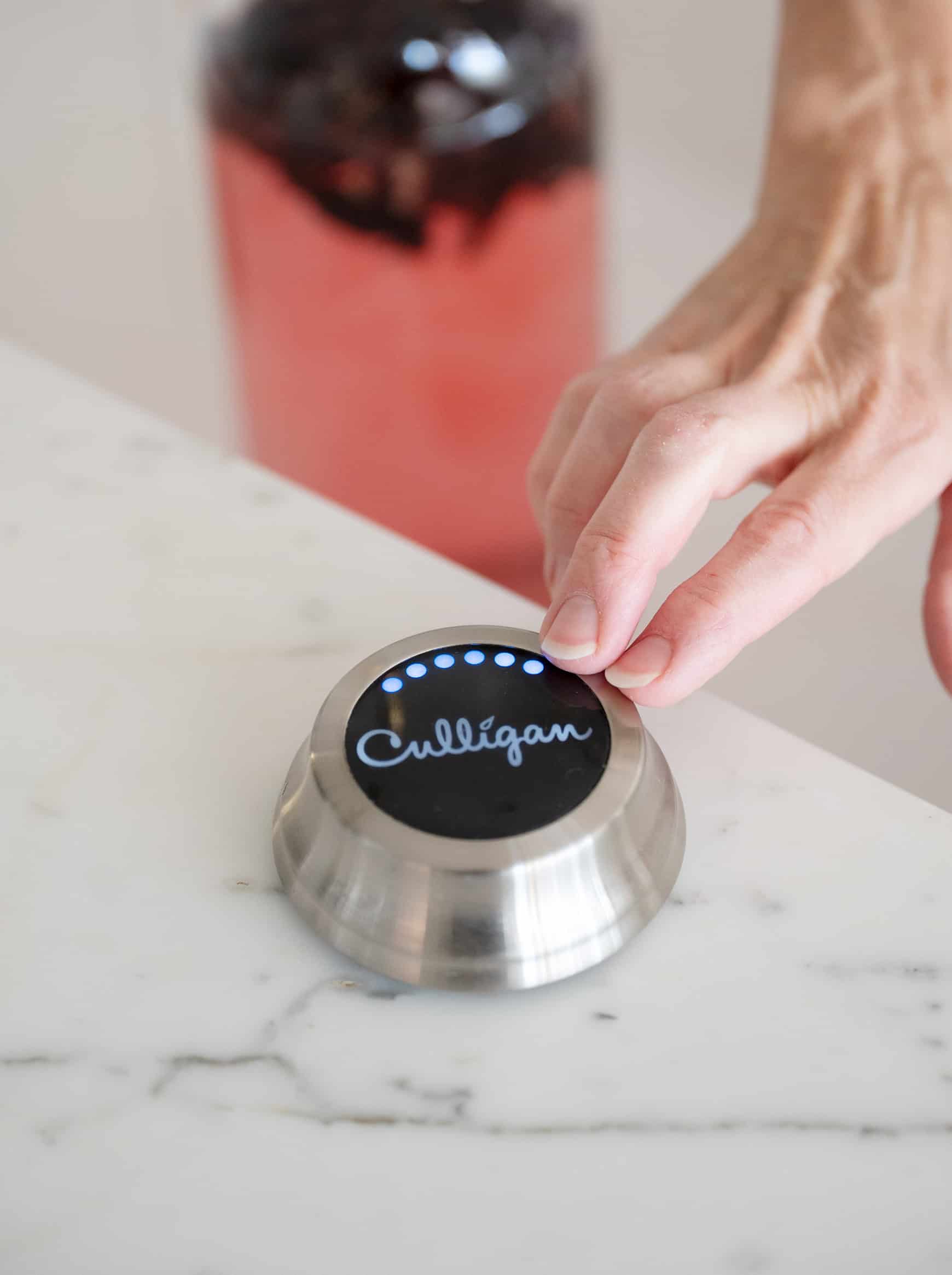 Pressing Culligan button to get filtered tap water