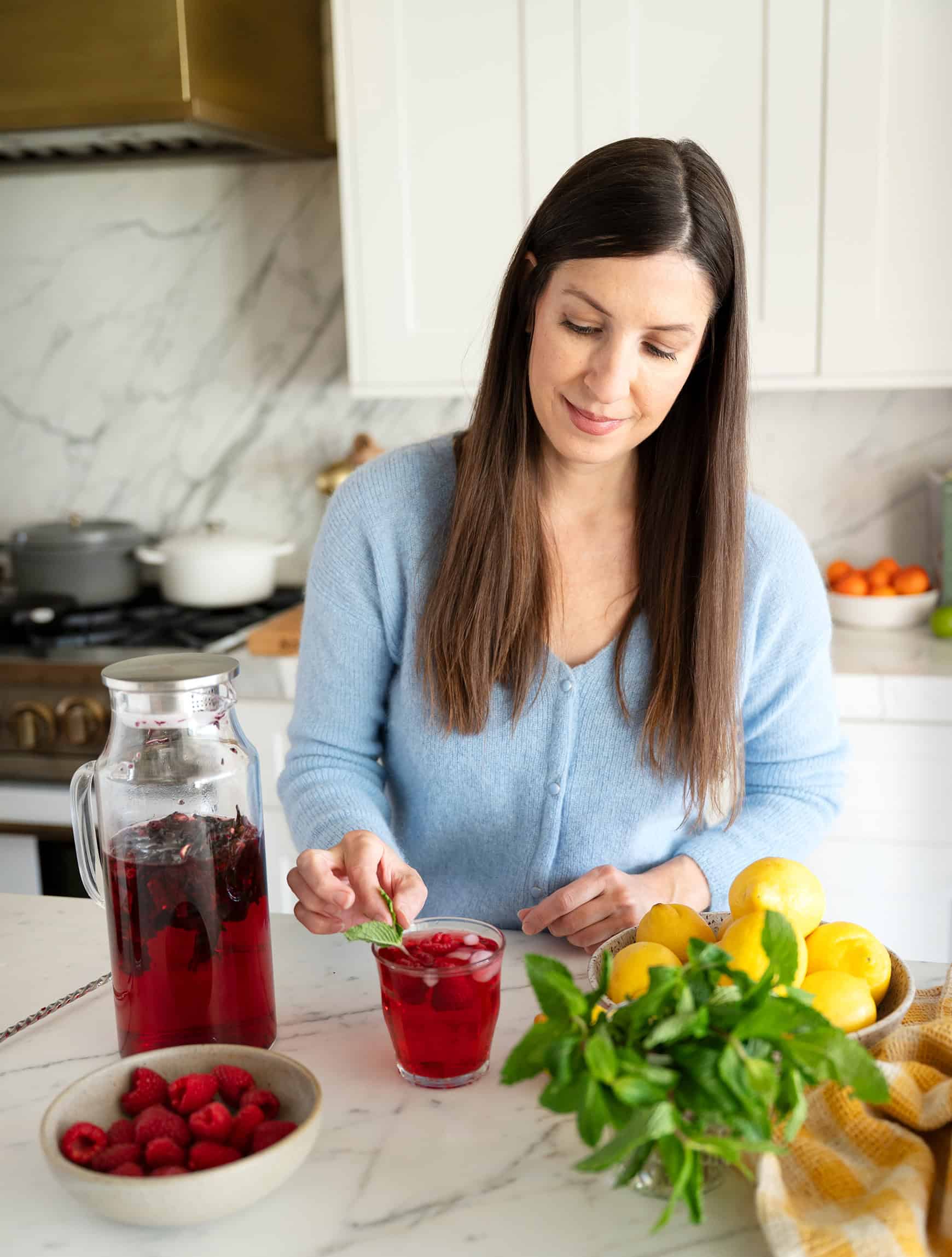 Jeanine garnishing glass of tea with fresh mint
