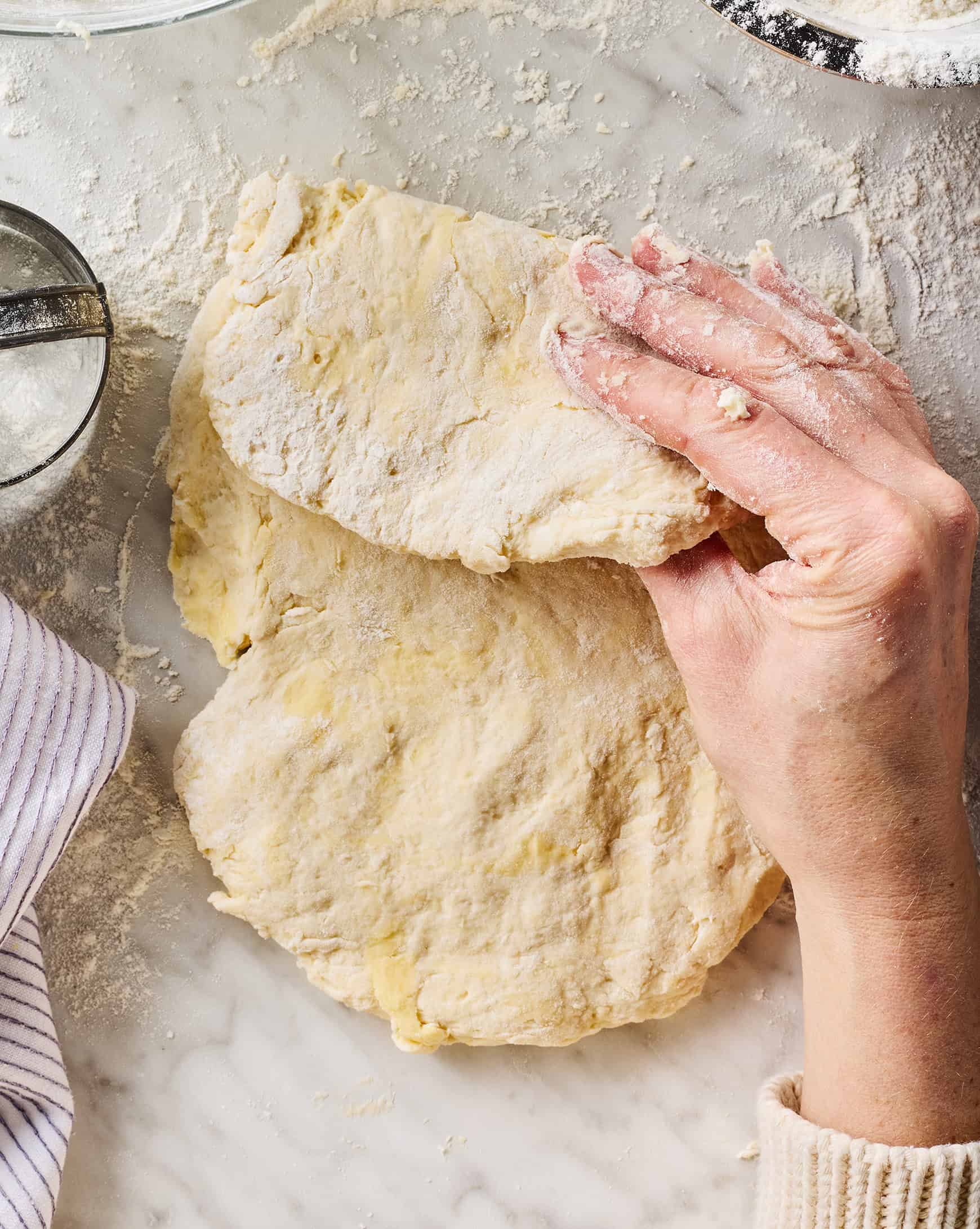 Hands folding biscuit dough