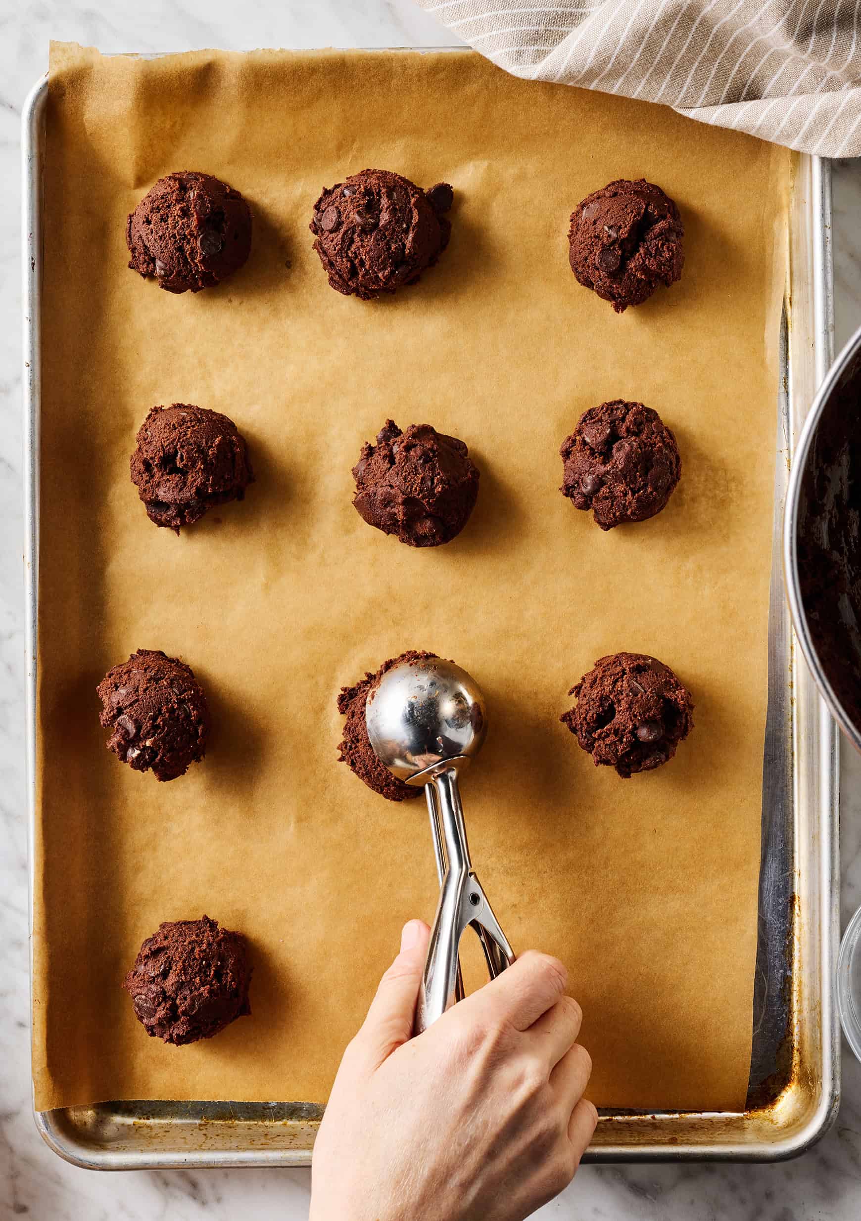 Scooping cookie dough balls onto baking sheet