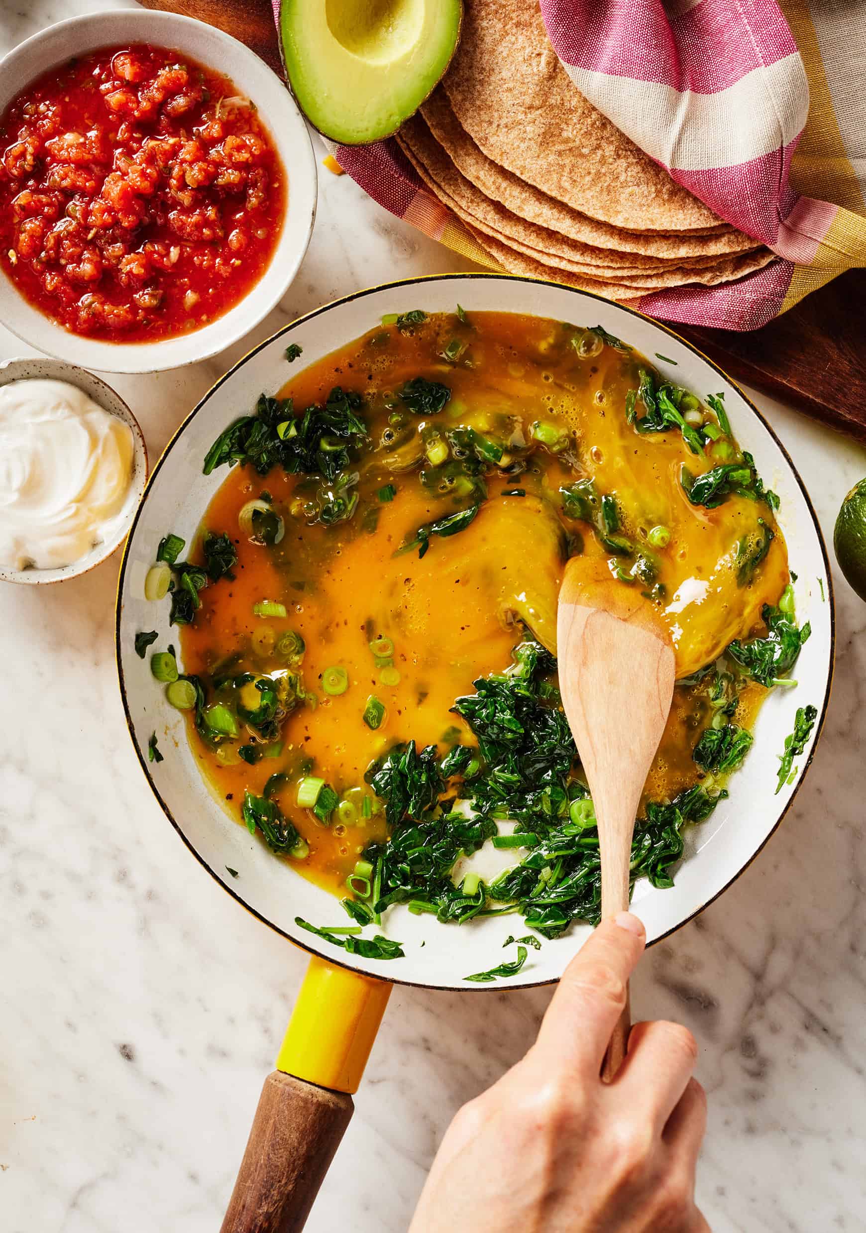 Scrambling eggs with spinach and scallions