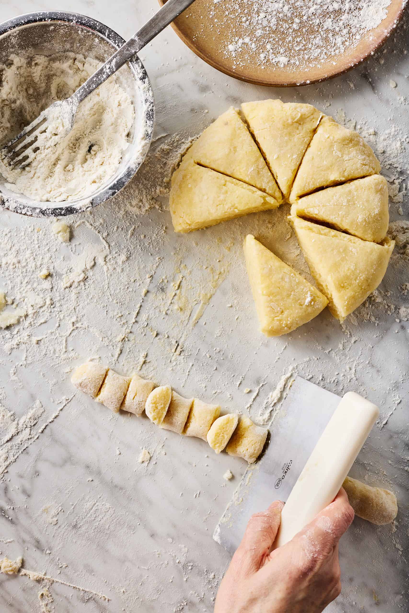 Slicing dough rope into individual gnocchi