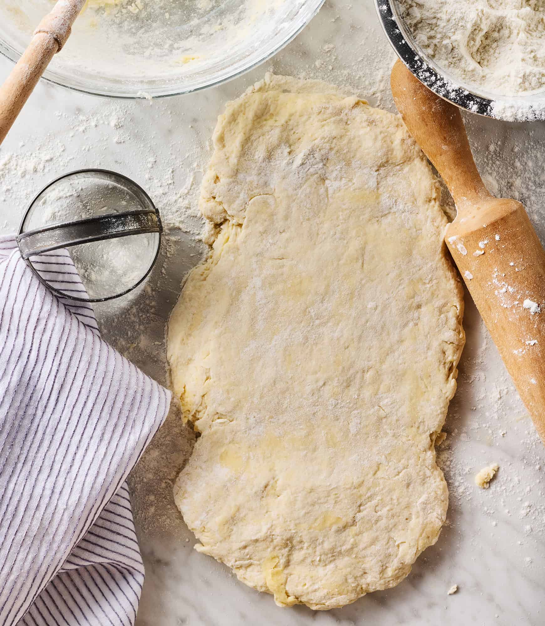 Dough for homemade biscuits rolled out on marble surface