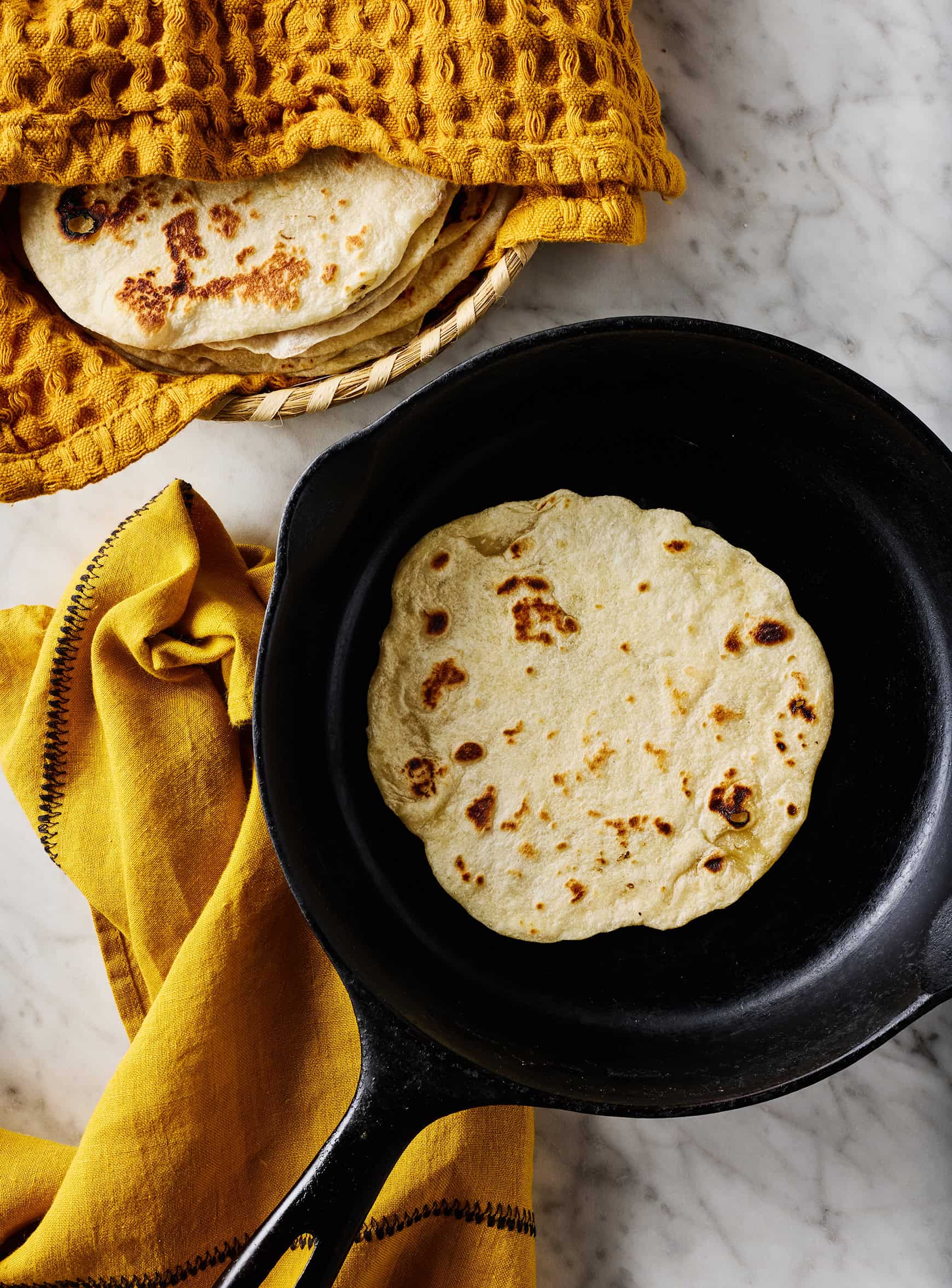 Cooking homemade flour tortilla in cast iron skillet