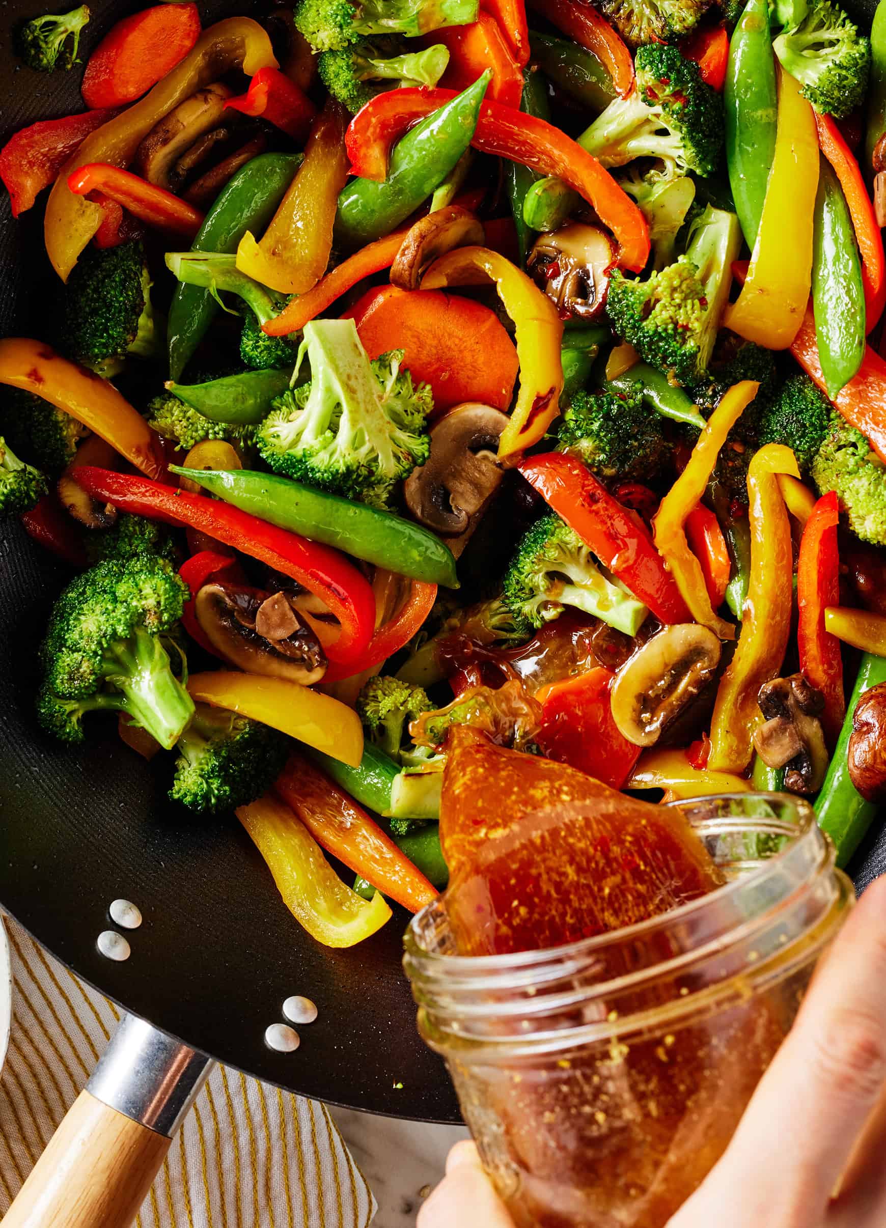 Pouring sauce into stir fry
