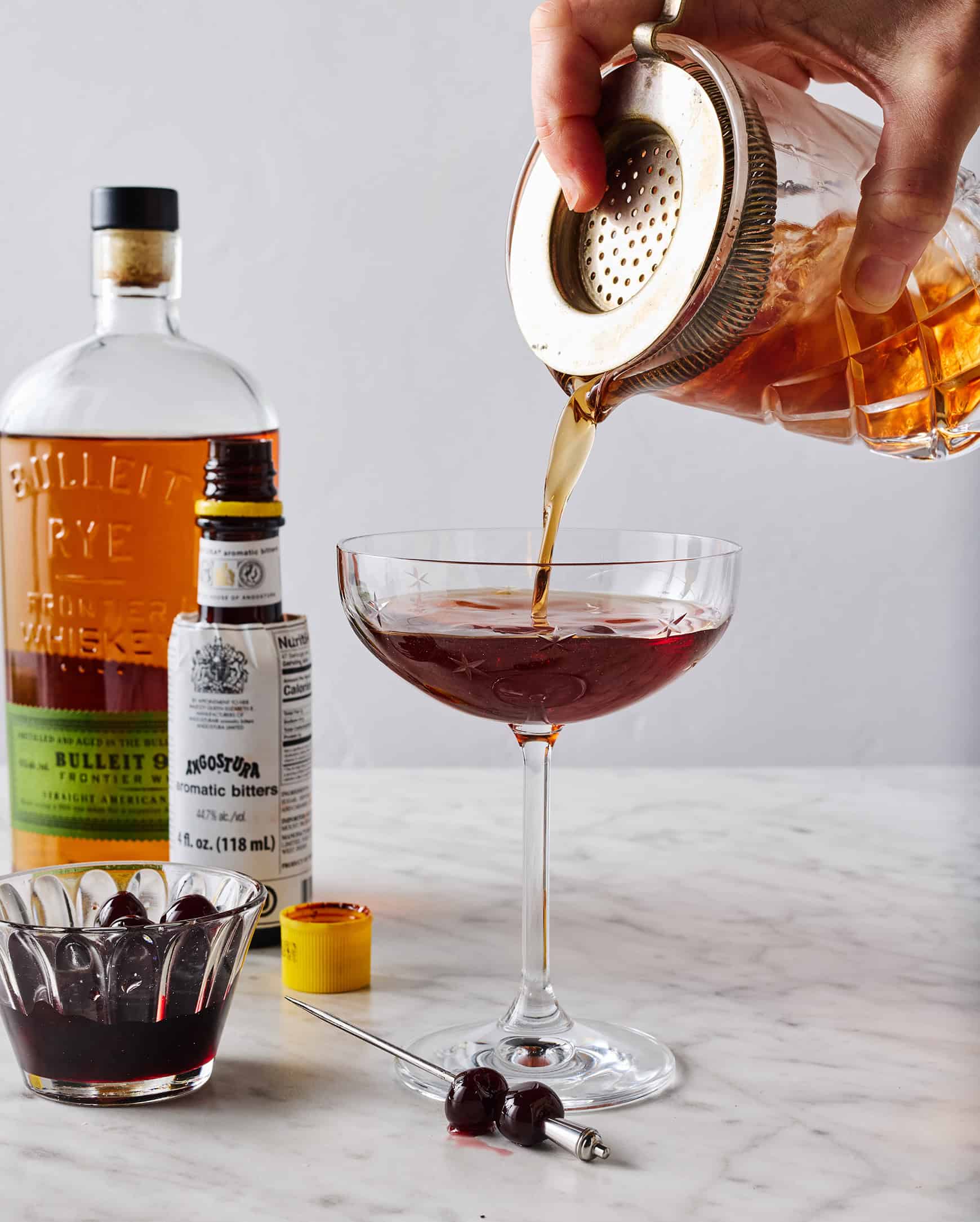 Straining drink into cocktail glass