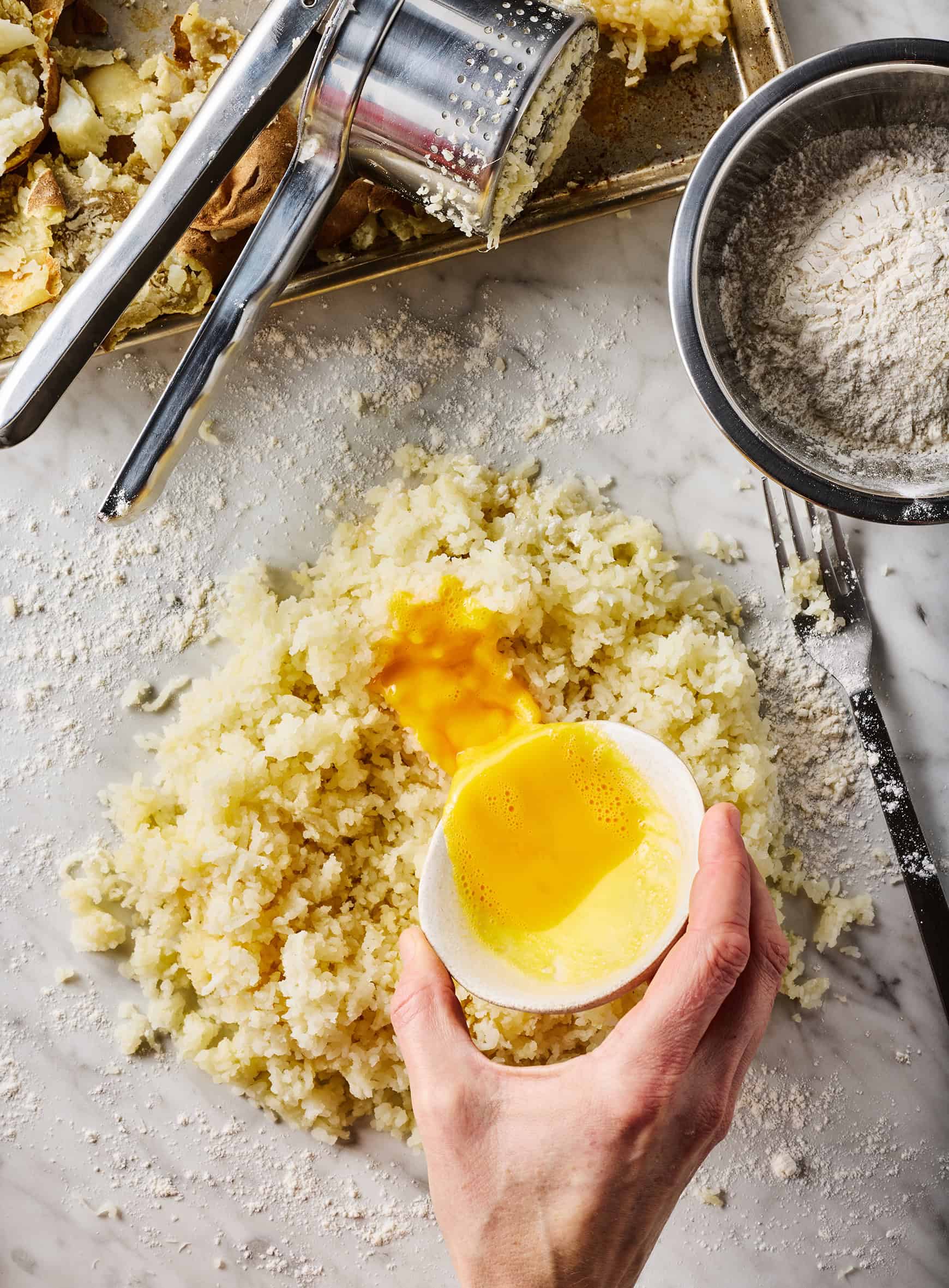 Pouring egg over riced potatoes