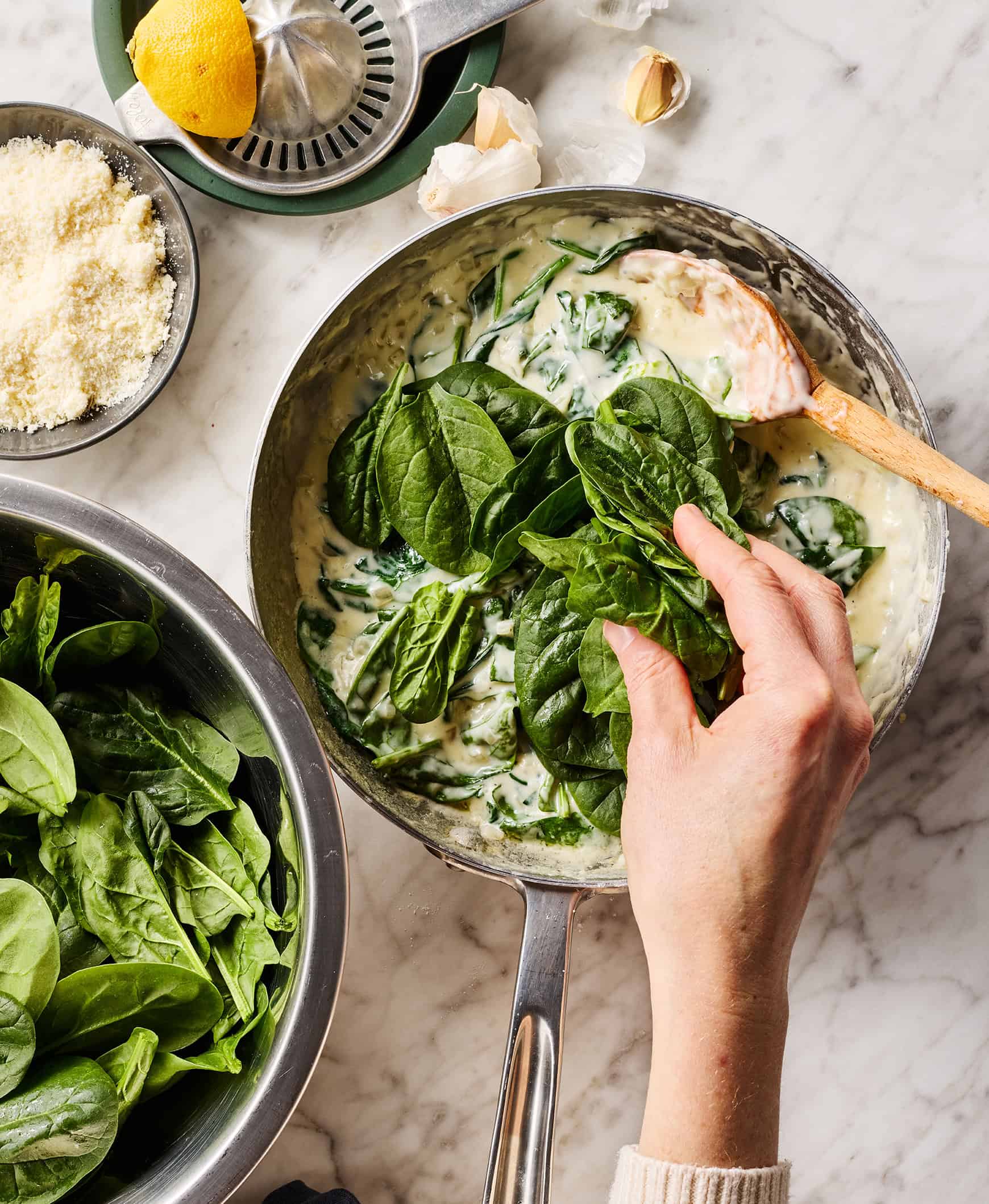 Adding spinach to thickened cream in skillet