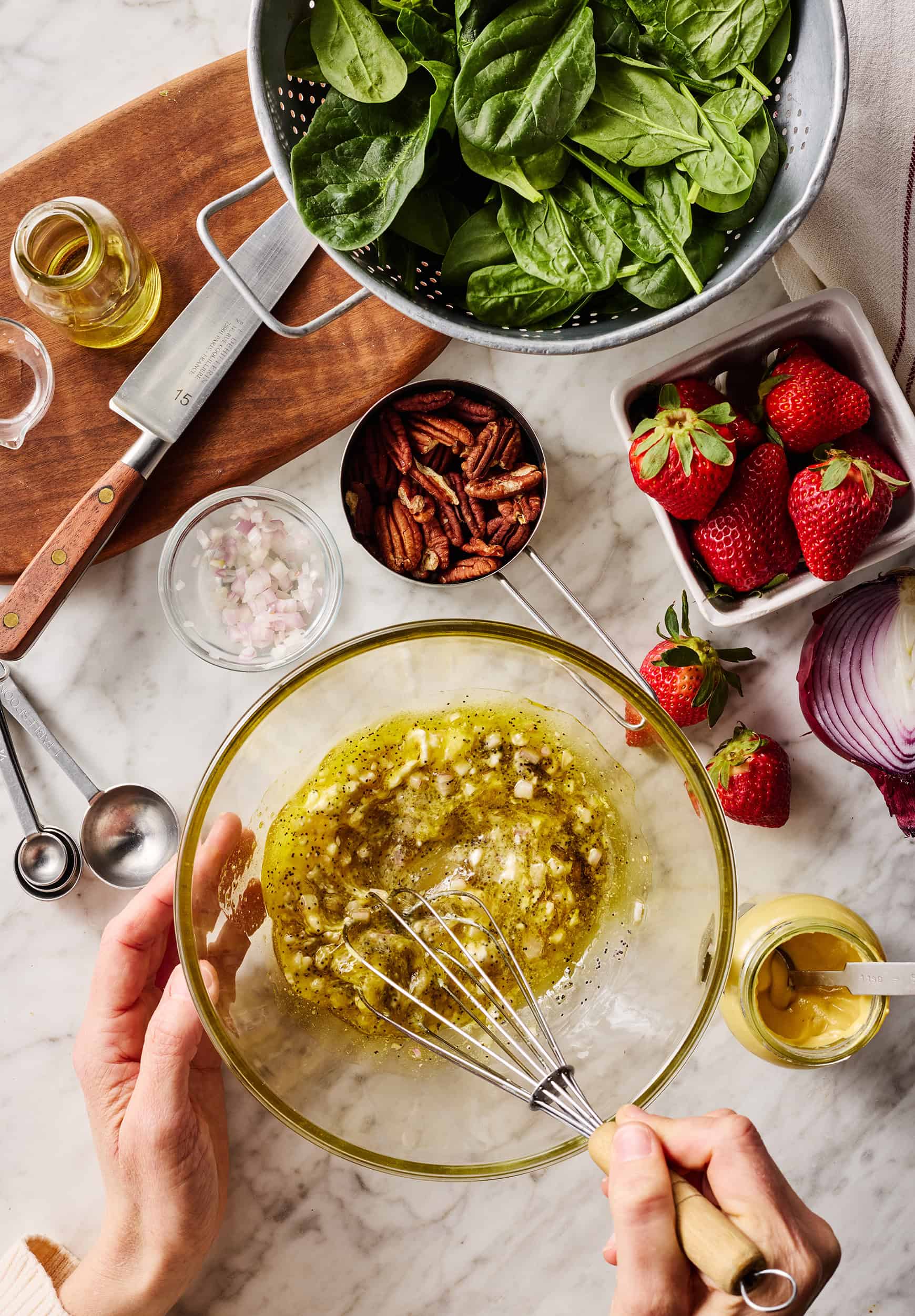 Whisking poppy seed dressing in glass bowl