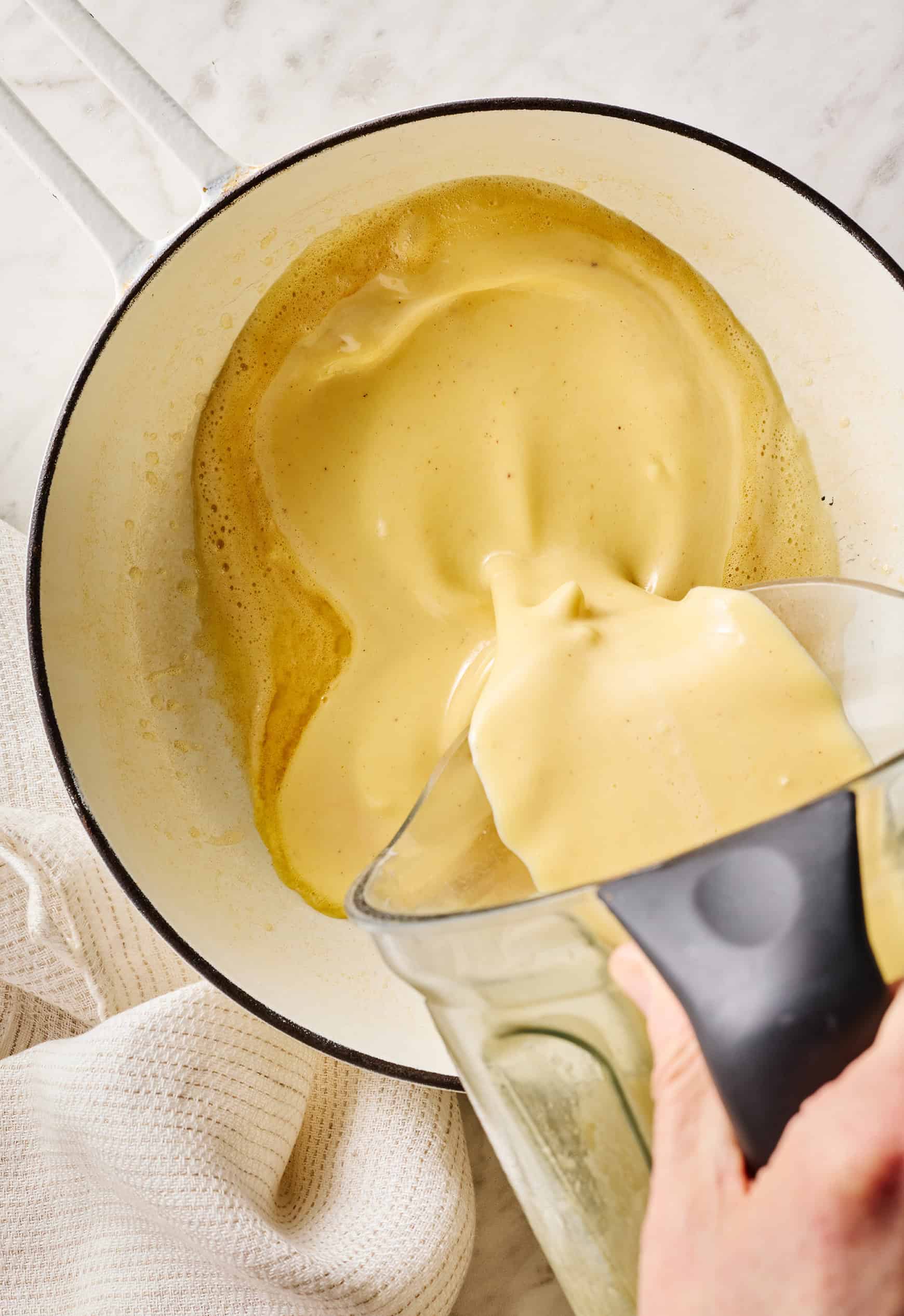 Pouring Dutch baby pancake batter into hot skillet