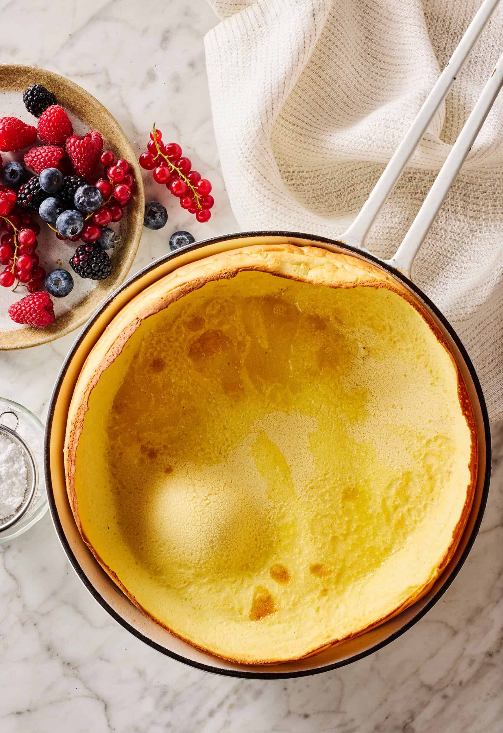 Puffed and golden Dutch baby in skillet