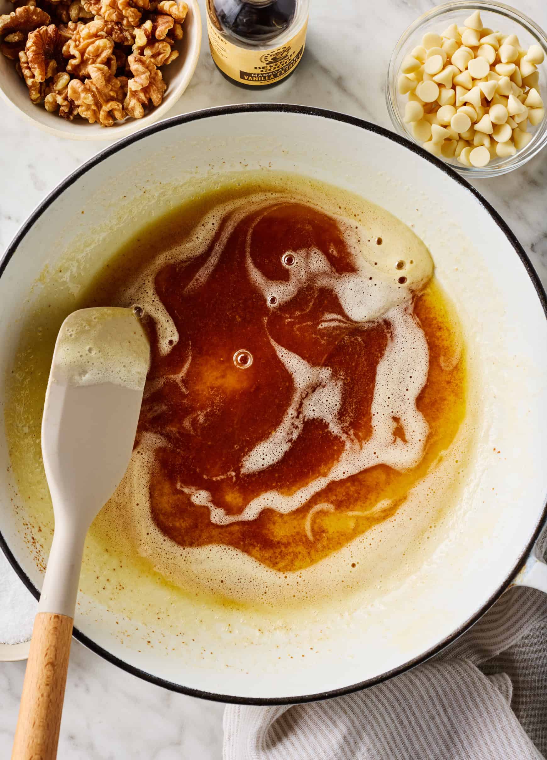 How to make browned butter - stirring butter with golden brown milk solids in white skillet
