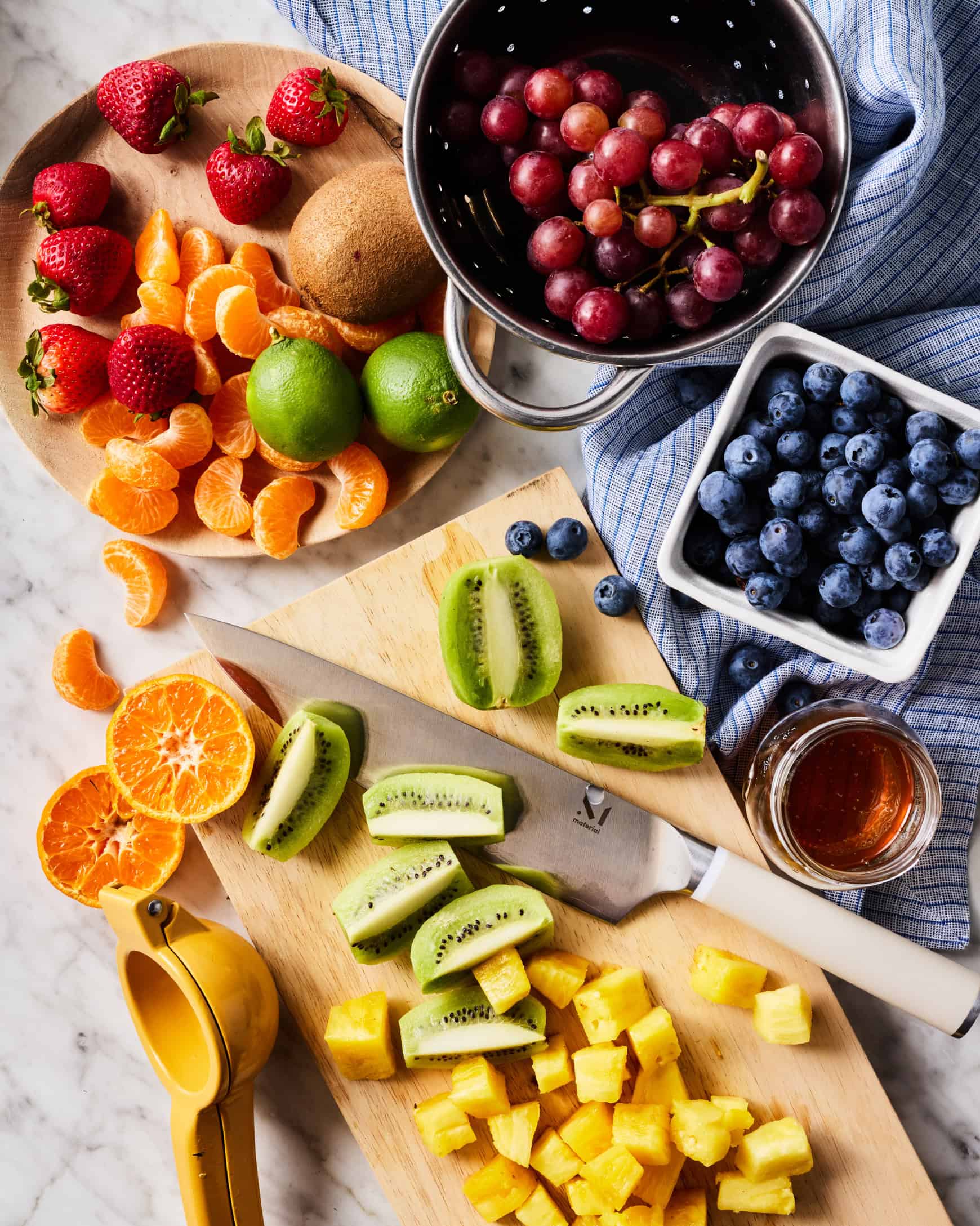 Fresh blueberries, strawberries, mandarins, grapes, kiwi, pineapple, limes, and honey