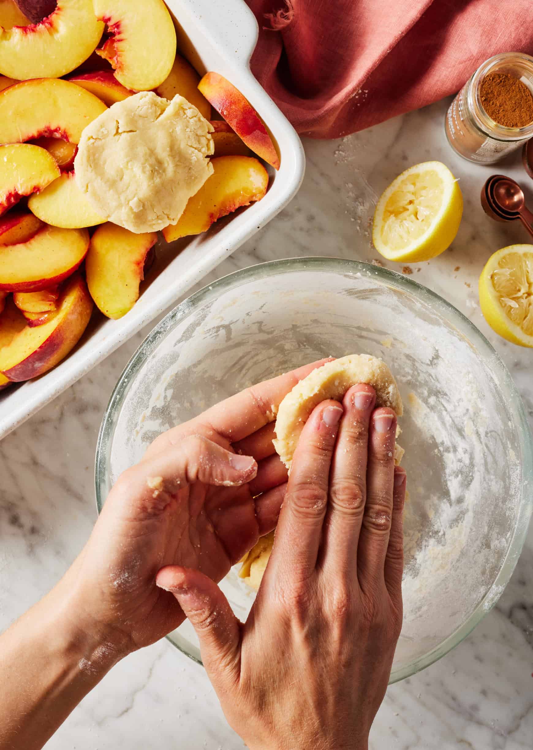 Hands flattening dough to form biscuits