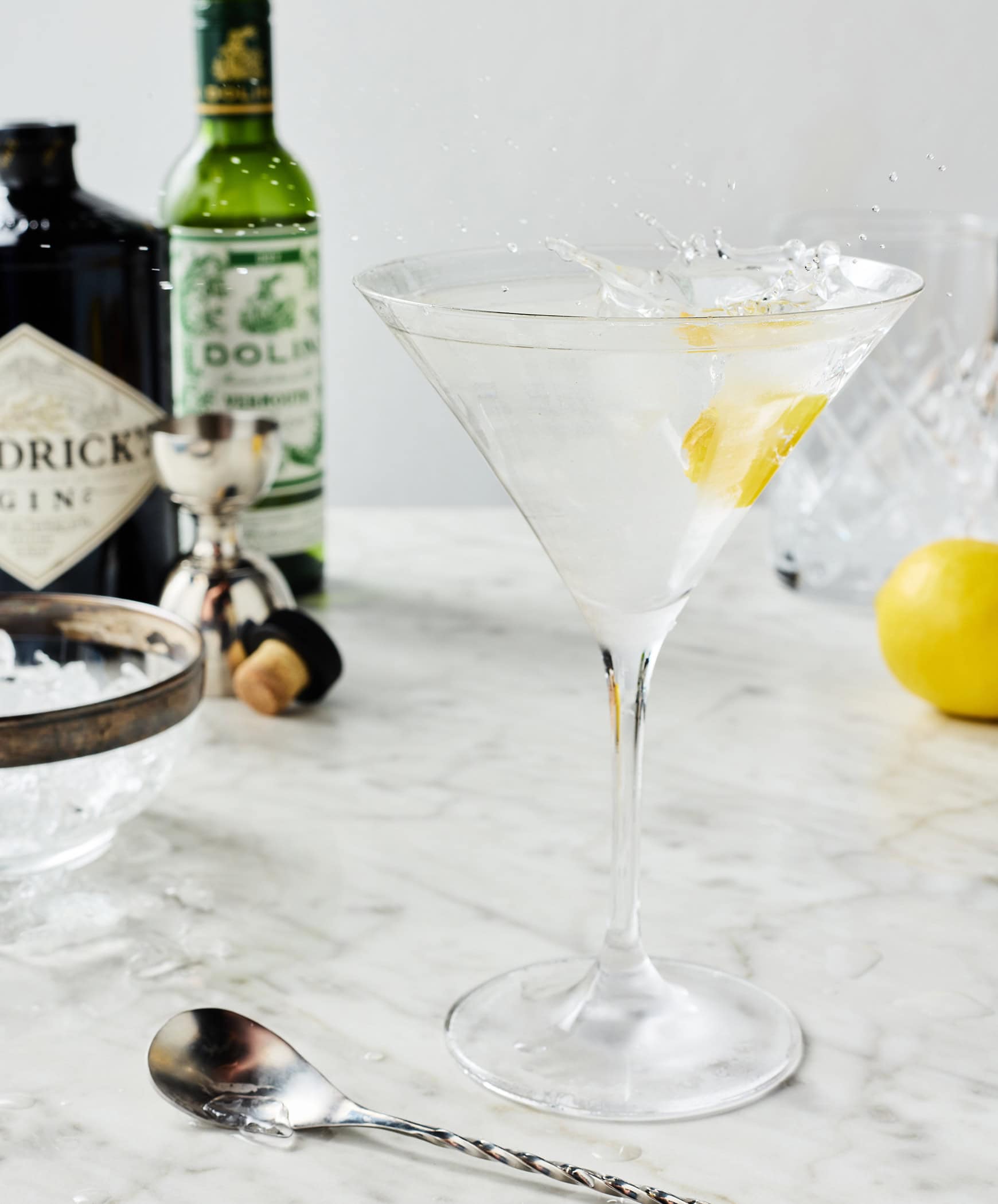 Dropping lemon twist into cocktail for garnish