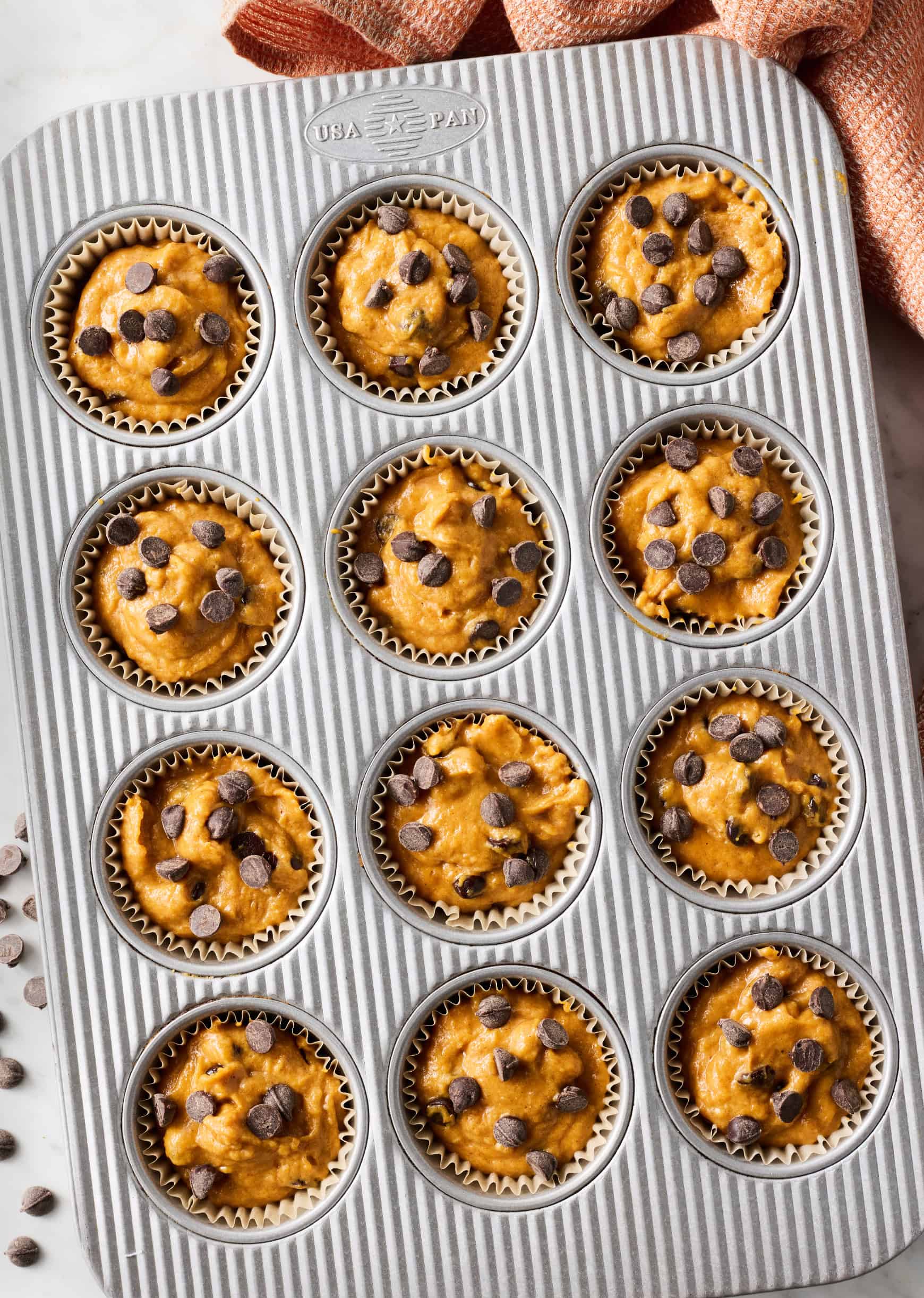 Pumpkin chocolate chip muffin batter in muffin in