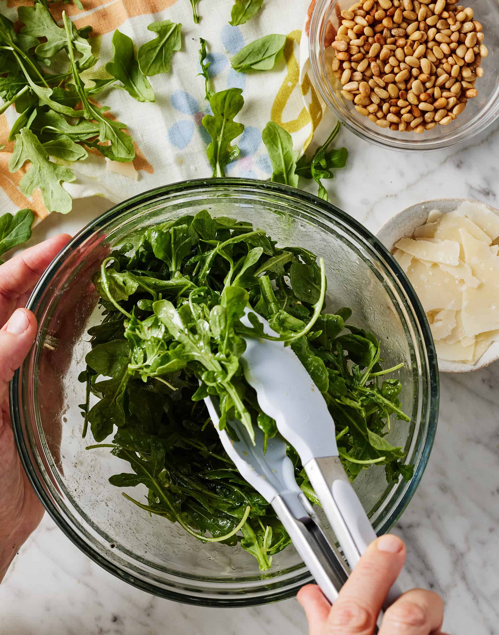 tossing arugula with dressing