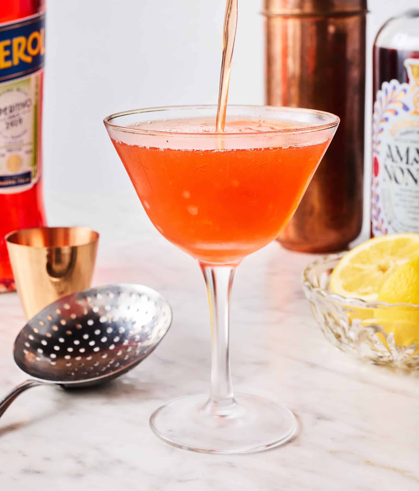 Pouring paper plane cocktail into glass