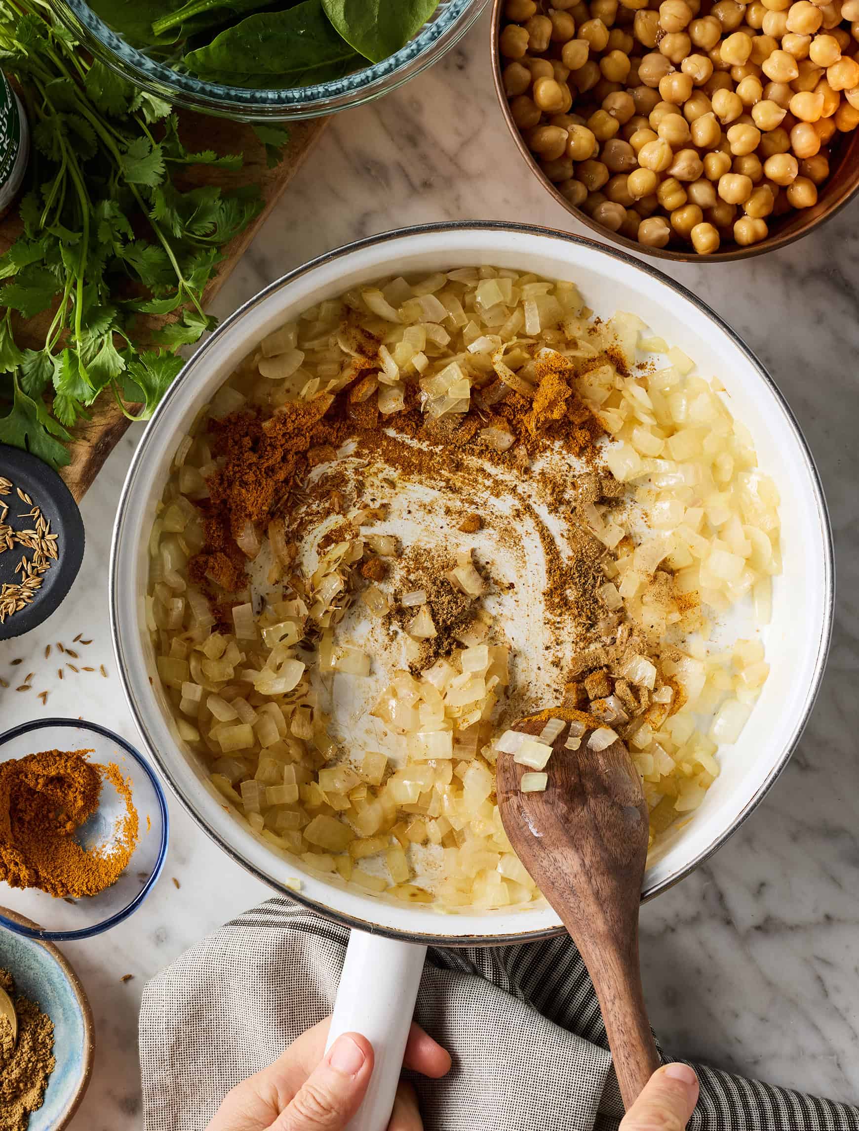 Stirring spices into sautéed onions in skillet