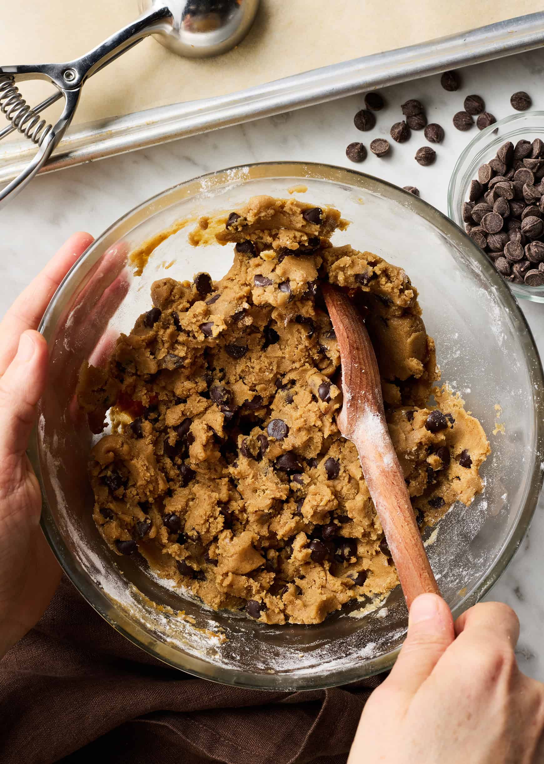Mixing cookie dough with wooden spoon in glass bowl
