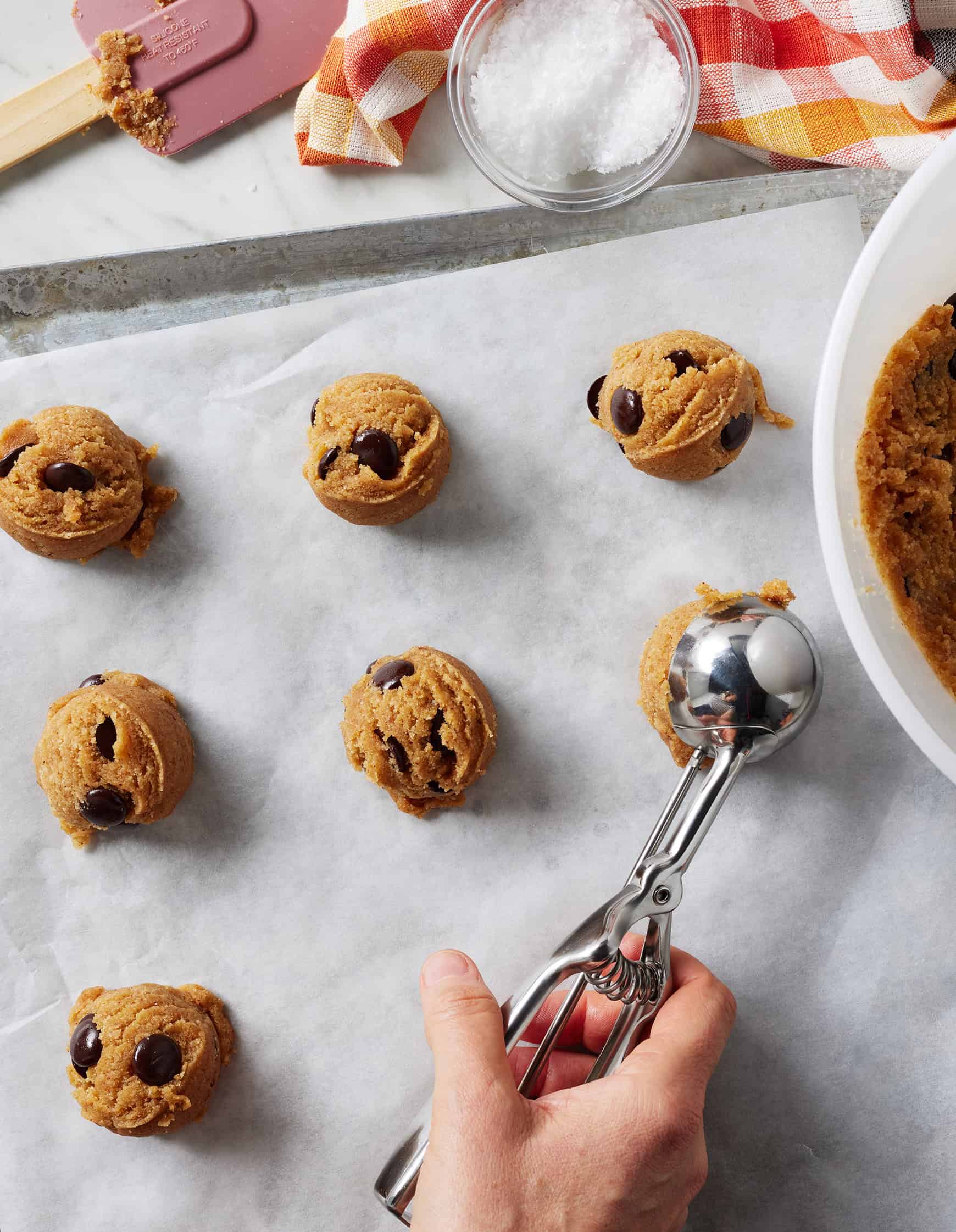 Scooping almond flour chocolate chip cookies onto baking sheet