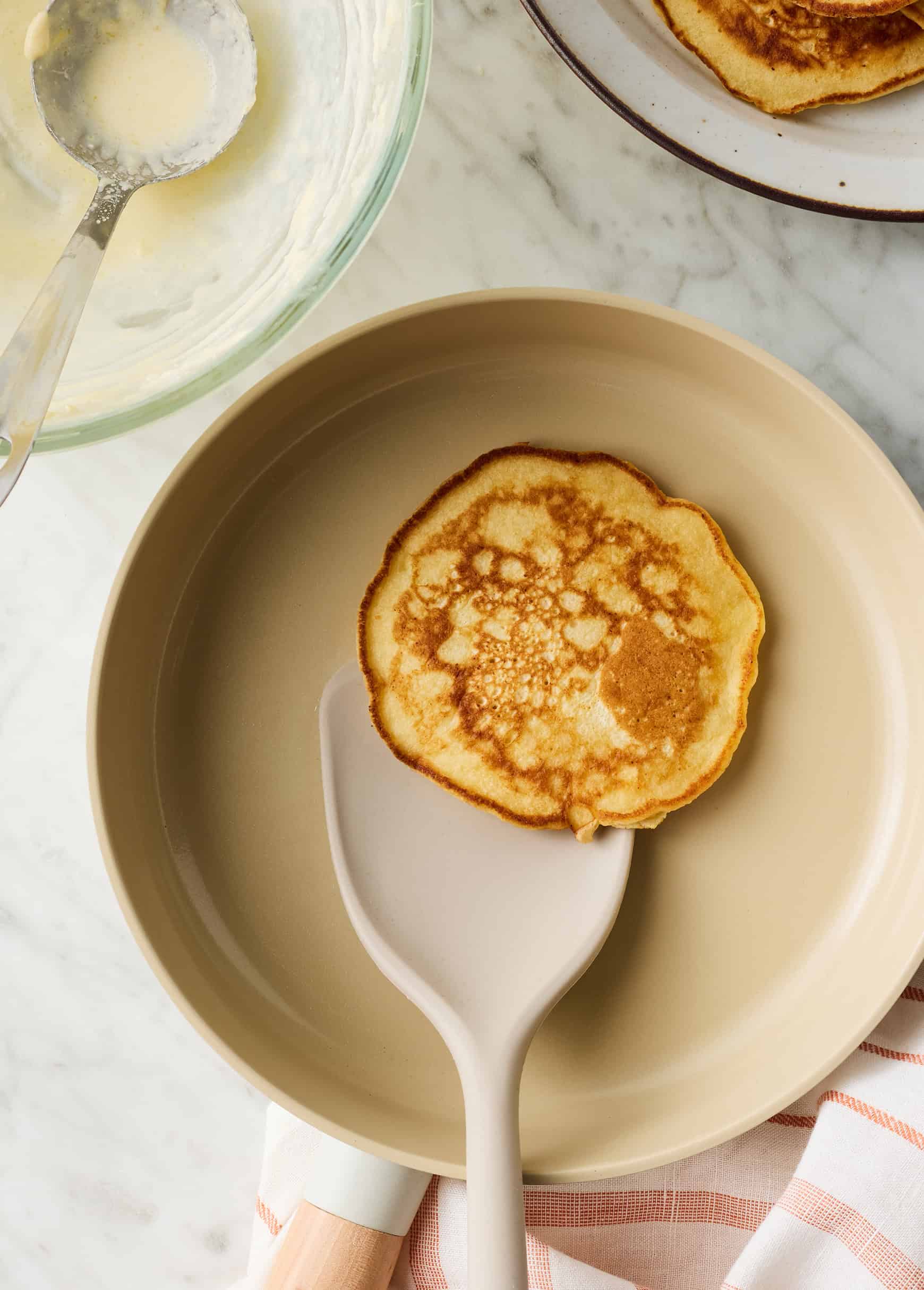 Flipping lemon ricotta pancake in skillet