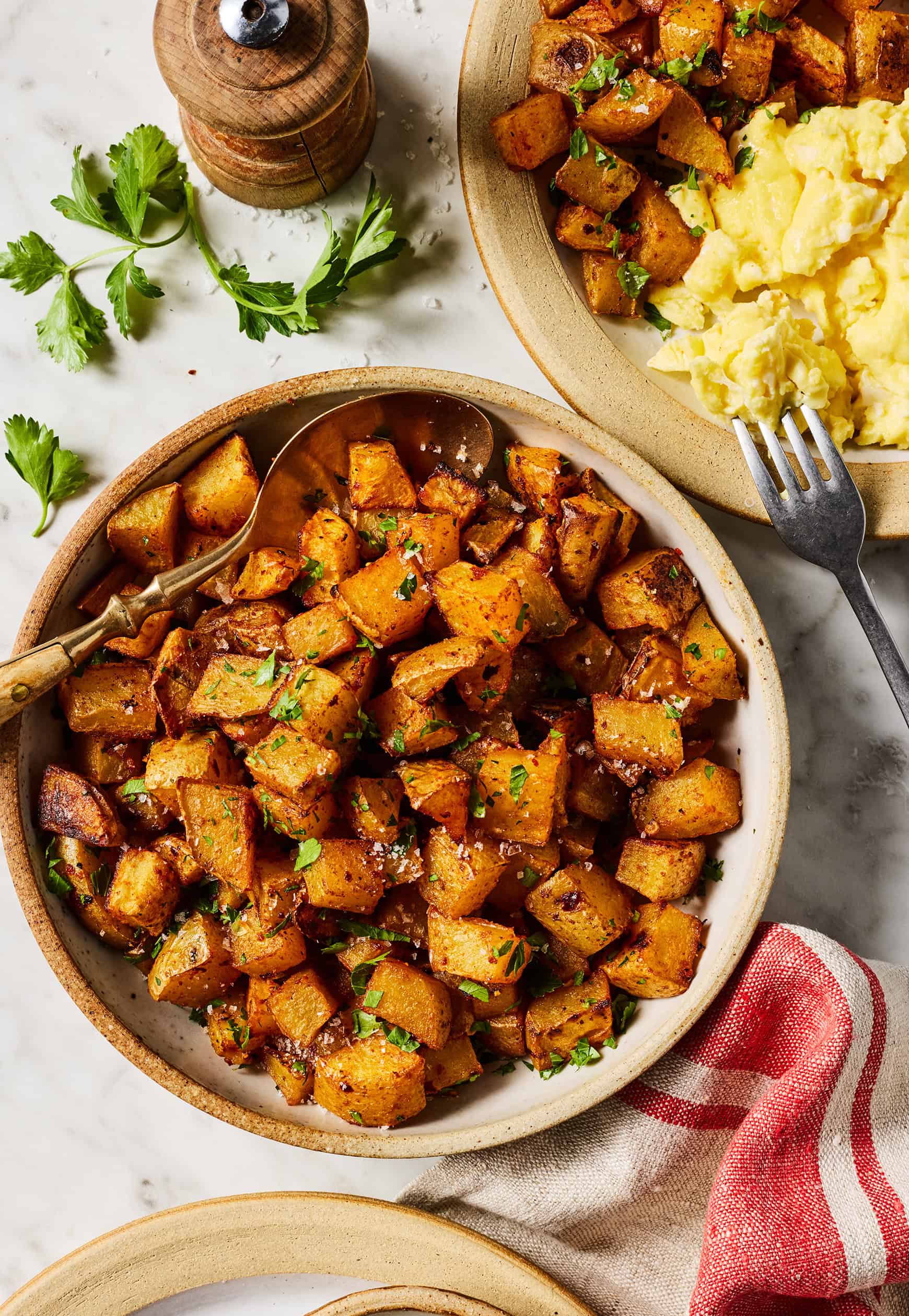 Bowl of Southwest potatoes next to plate of scrambled eggs