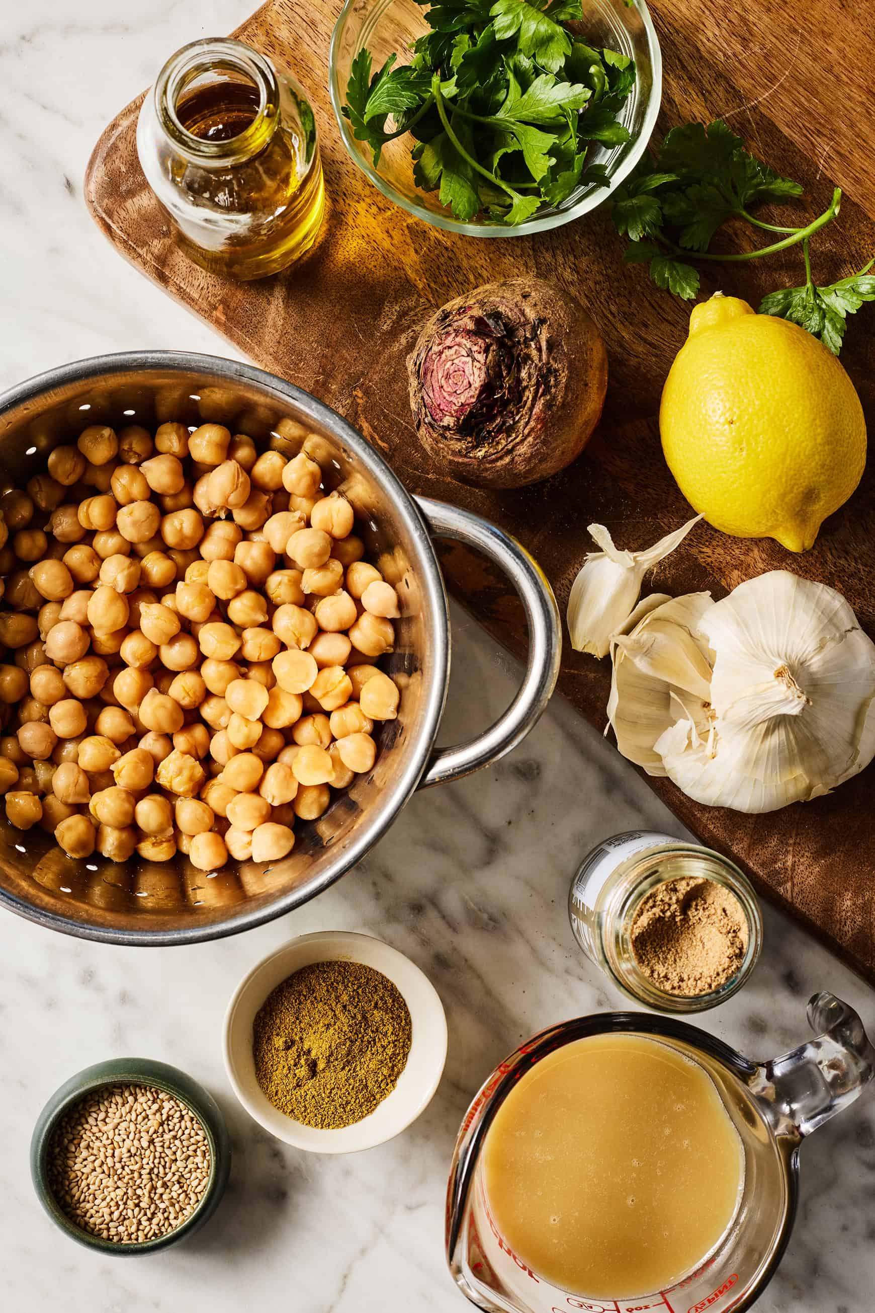 Recipe ingredients - fresh beet, chickpeas, tahini, cumin, coriander, garlic, lemon, olive oil, parsley, and sesame