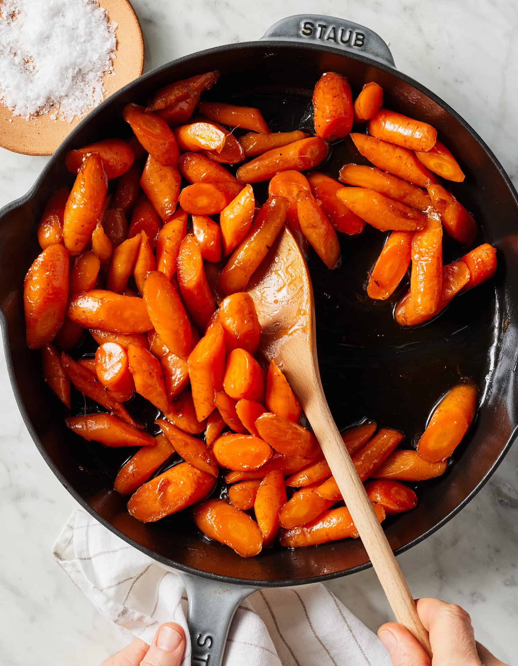 Tossing carrots with brown sugar glaze in skillet