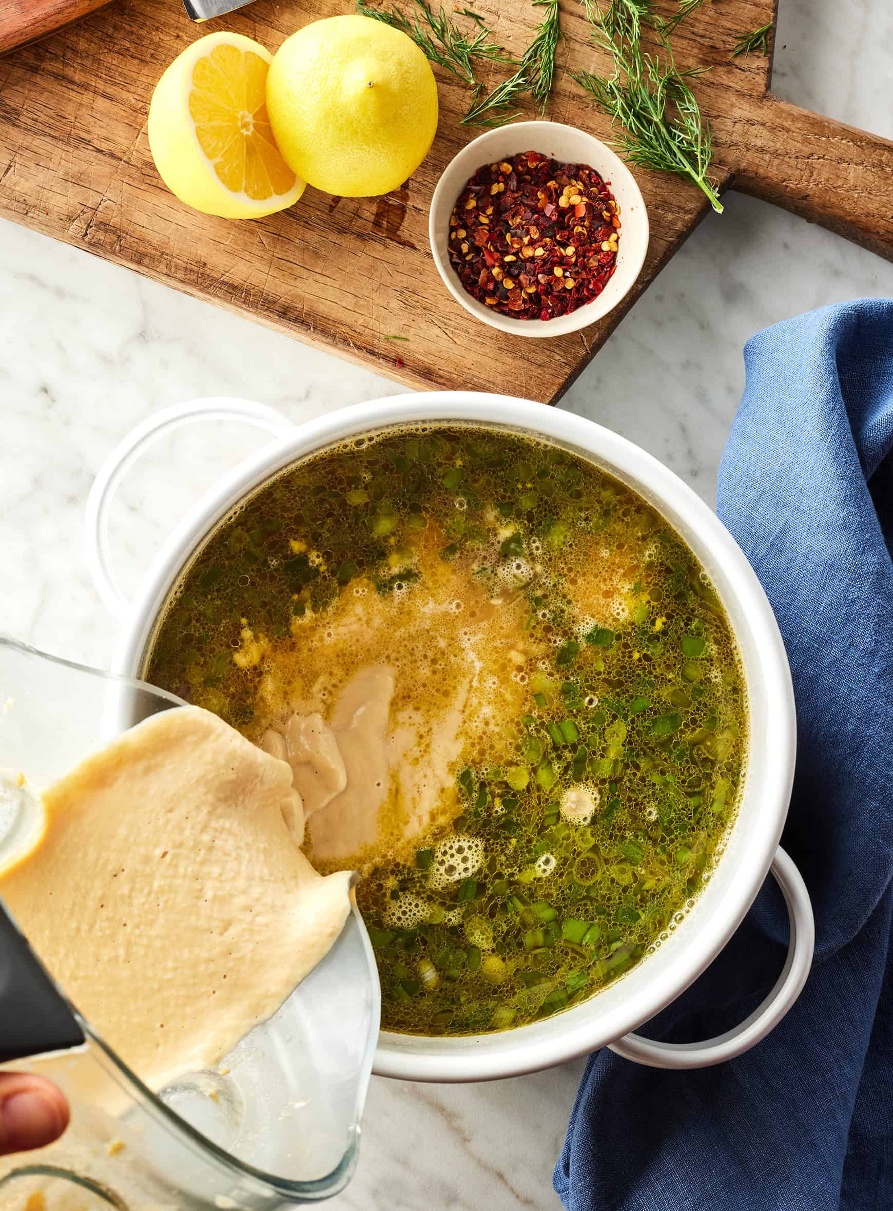 Pouring bean puree into pot with broth