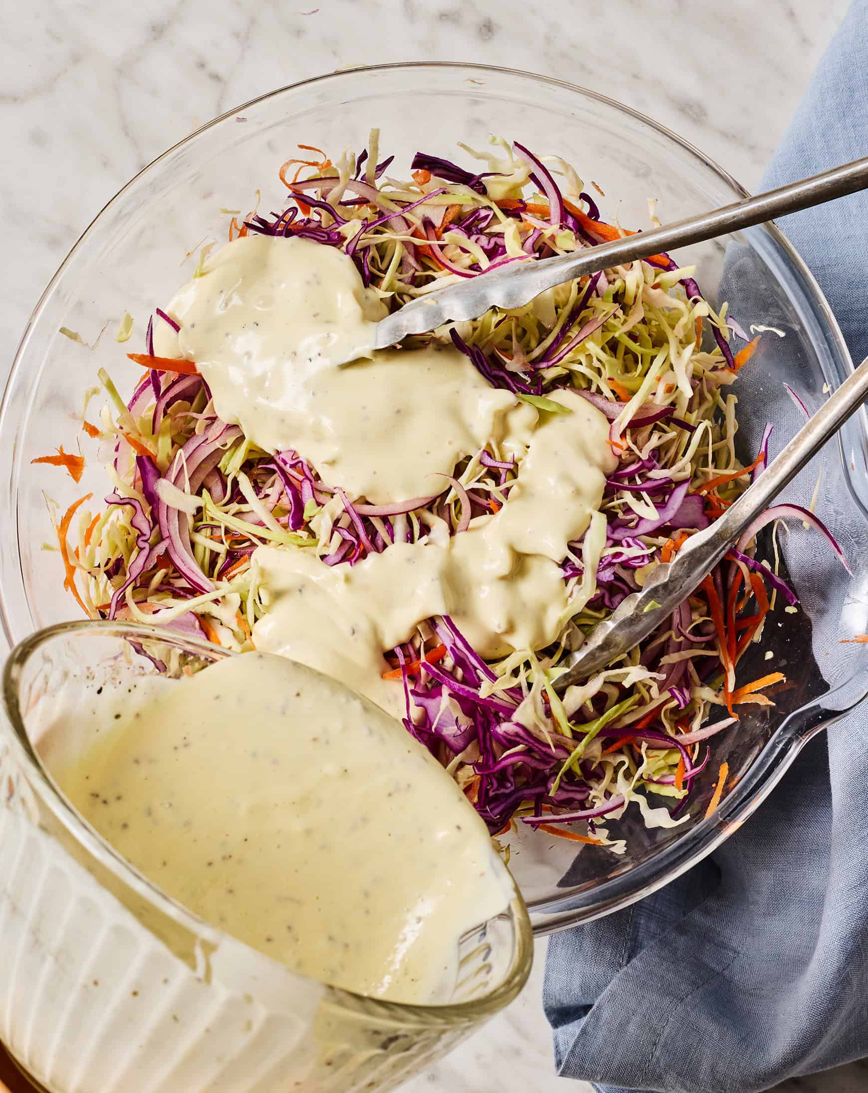 Tossing shredded cabbage with creamy dressing