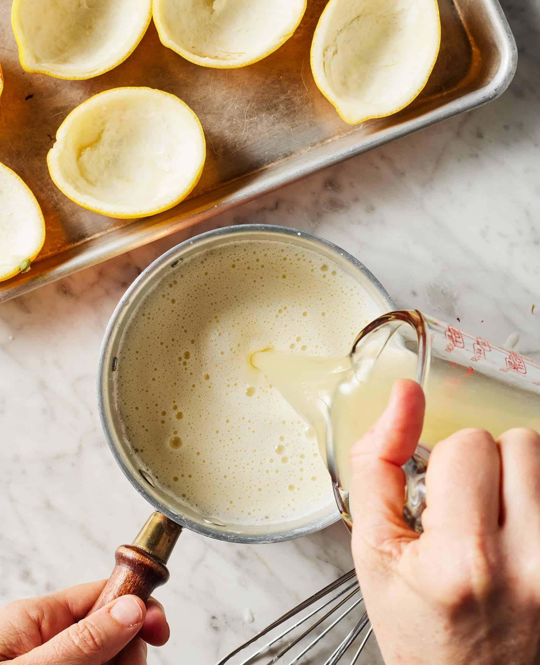 Pouring lemon juice into cream mixture in saucepan